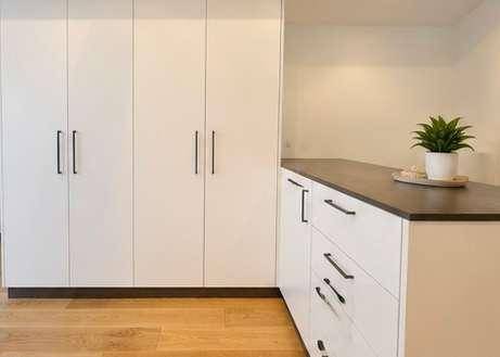 Heller Flur mit Einbauschränken und Holzboden, bietet viel Stauraum.
