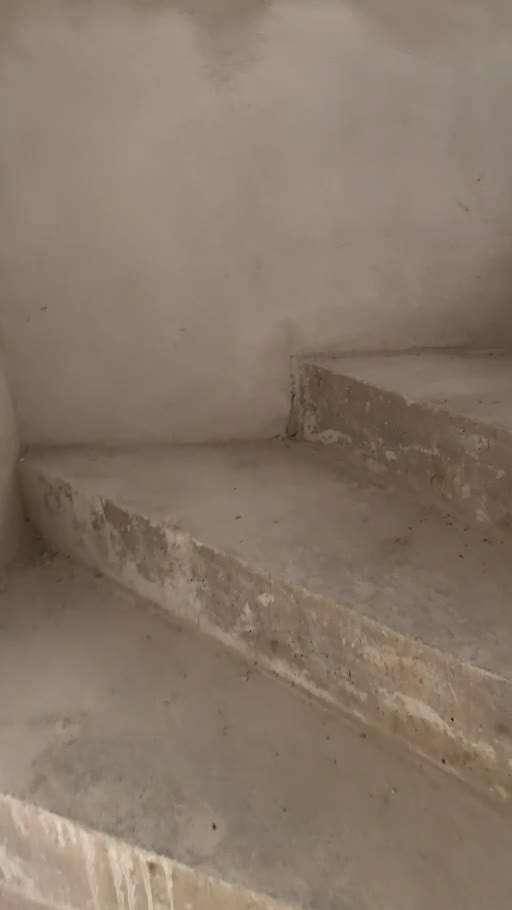 Rohbau-Treppe aus Beton in einem unfertigen Innenbereich, solide Bauweise erkennbar.