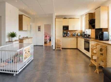 Offener Wohnbereich mit integrierter Küche und Kinderbett, ideal für Familien.