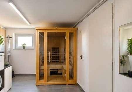 Wellnessbereich im Keller mit moderner Sauna und praktischem Spiegel.