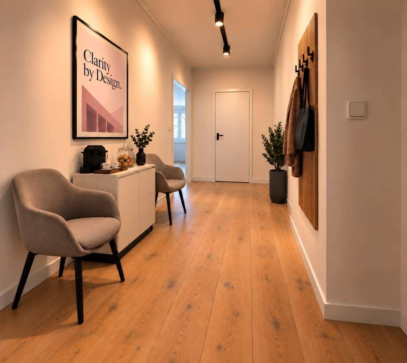 Moderner Flur mit Holzboden, Garderobe und stilvoller Dekoration, die zum Eingangsbereich führt.