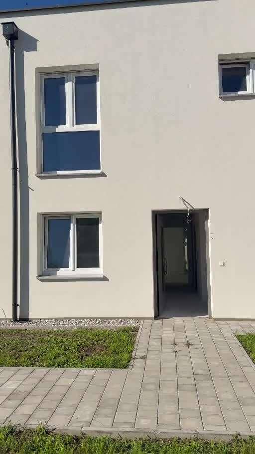 Moderne Hausfassade mit Fenstern und Eingangsbereich, sauber und neuwertig.