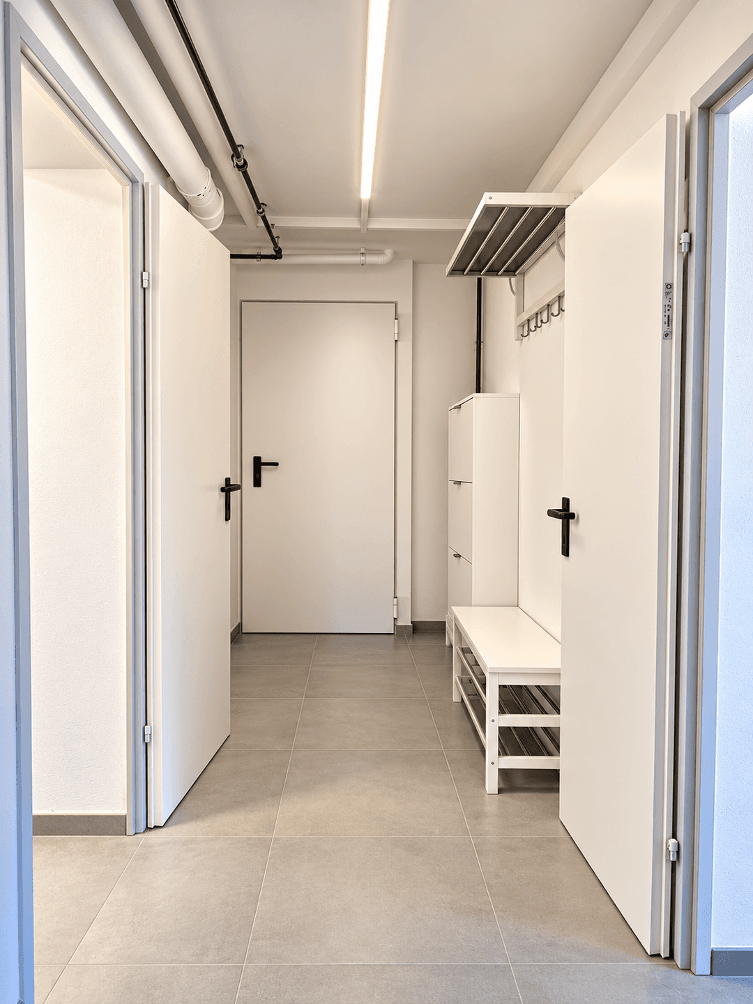 Heller Flur mit Garderobe und Schuhregal, bietet praktischen Stauraum.