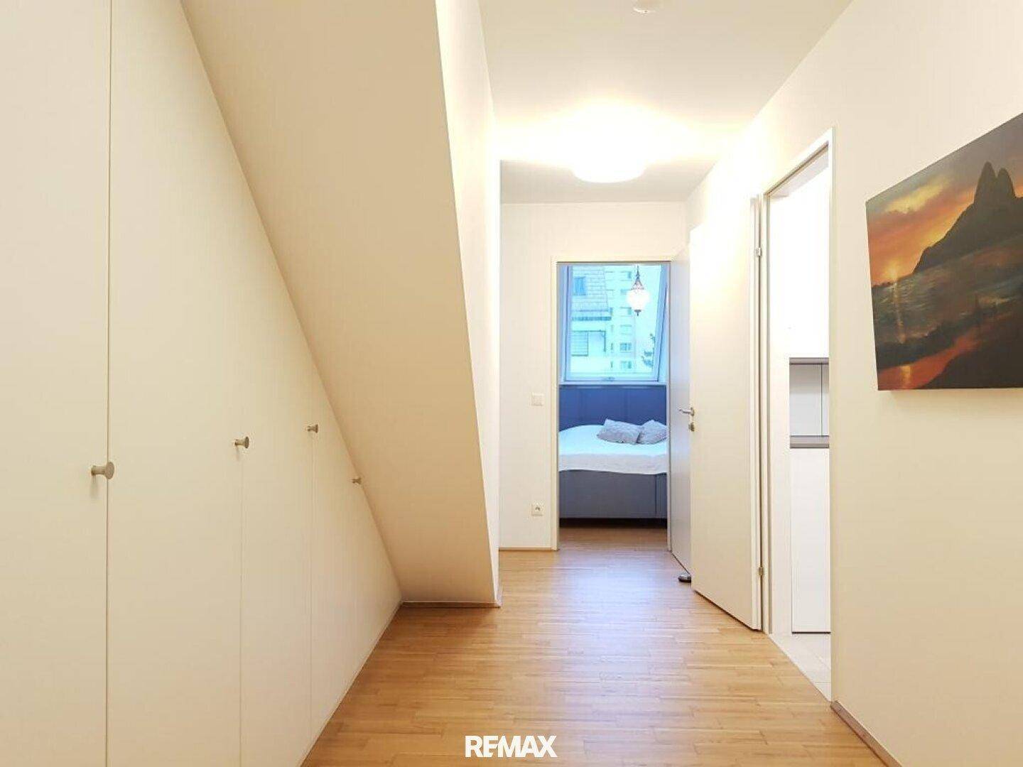Heller Flur mit praktischen Einbauschränken und Zugang zu einem weiteren Zimmer.