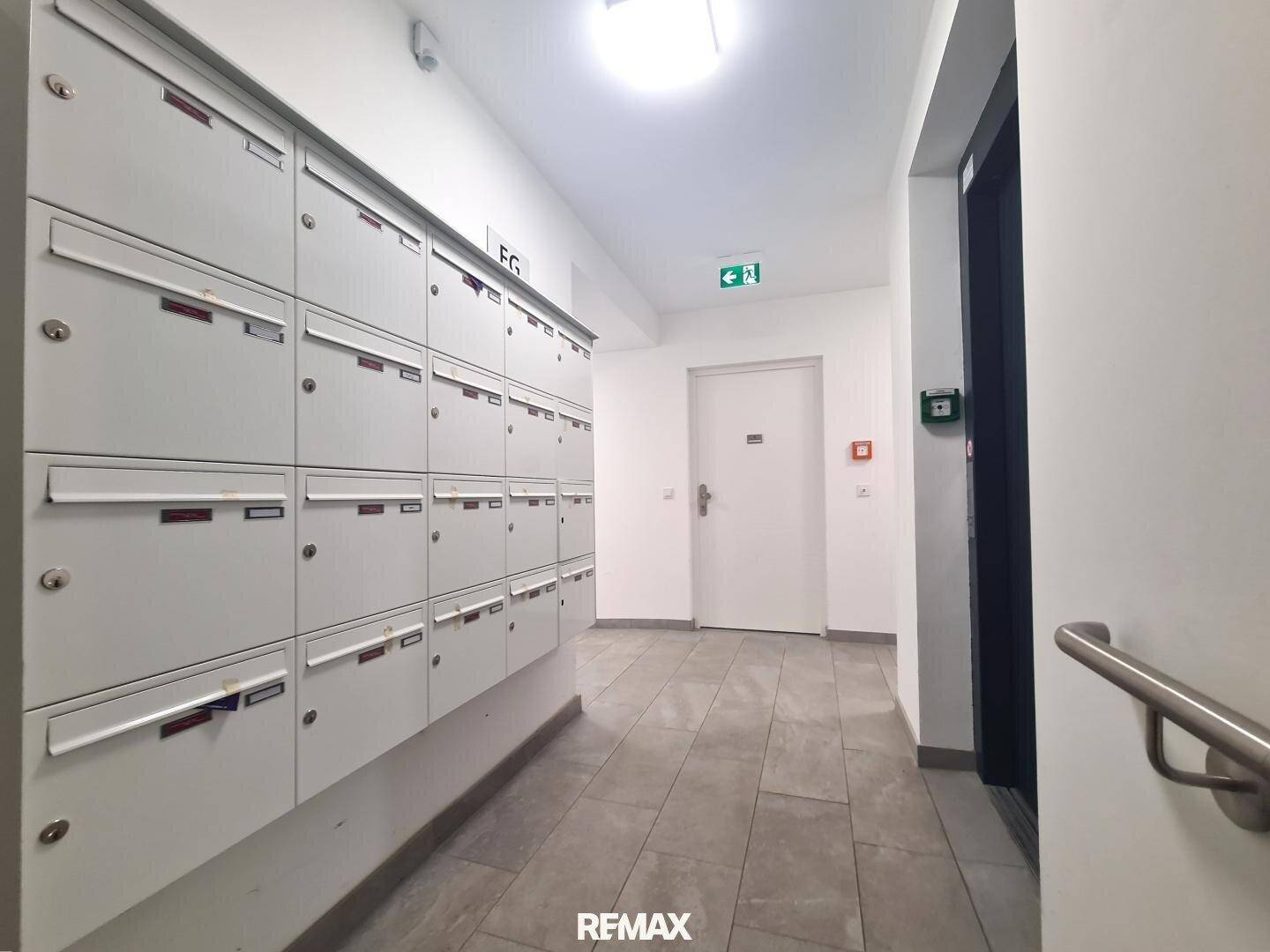 Eingangsbereich mit Briefkästen und einem Aufzug, der Zugang zu den oberen Etagen bietet.