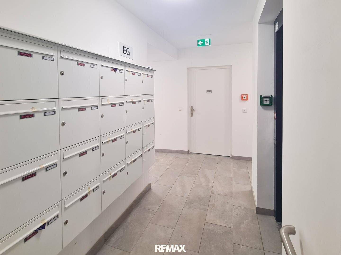 Eingangsbereich mit Briefkästen und einem Aufzug, der Zugang zu den oberen Etagen bietet.