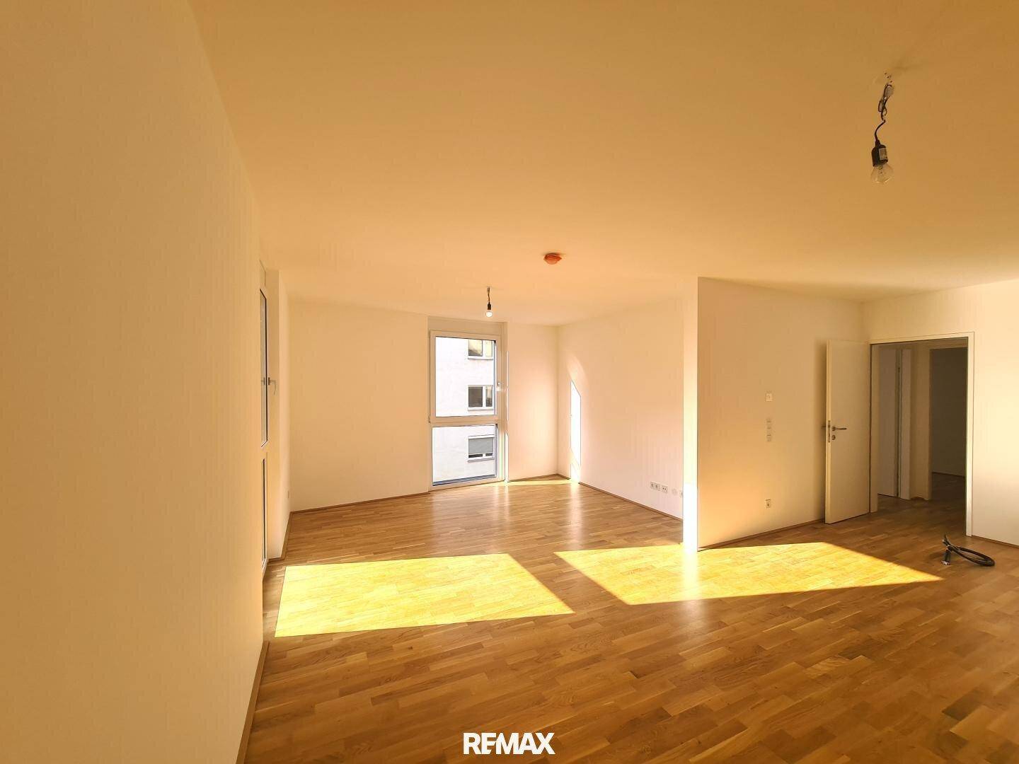 Geräumiges, helles Zimmer mit Parkettboden und mehreren Fenstern, die viel Licht spenden.
