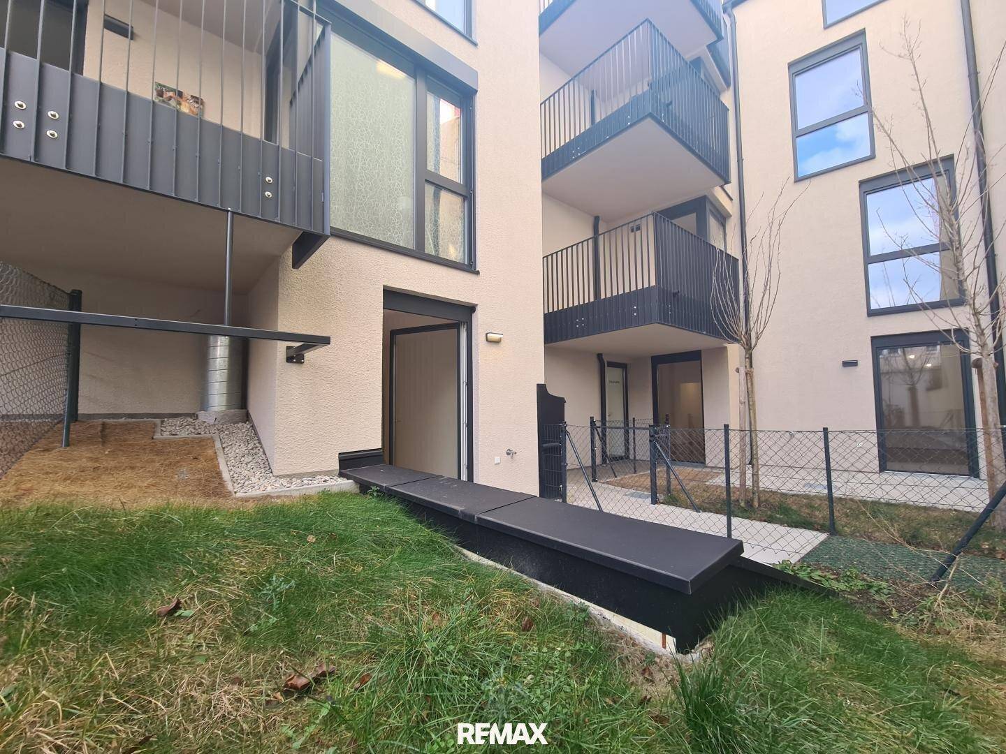 Erdgeschoss-Terrasse mit kleinem Gartenbereich und modernem Zugang zum Wohnraum.