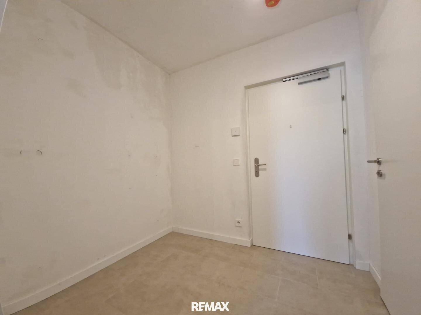 Eingangsbereich mit Fliesenboden und weißer Tür, bietet direkten Zugang zur Wohnung.