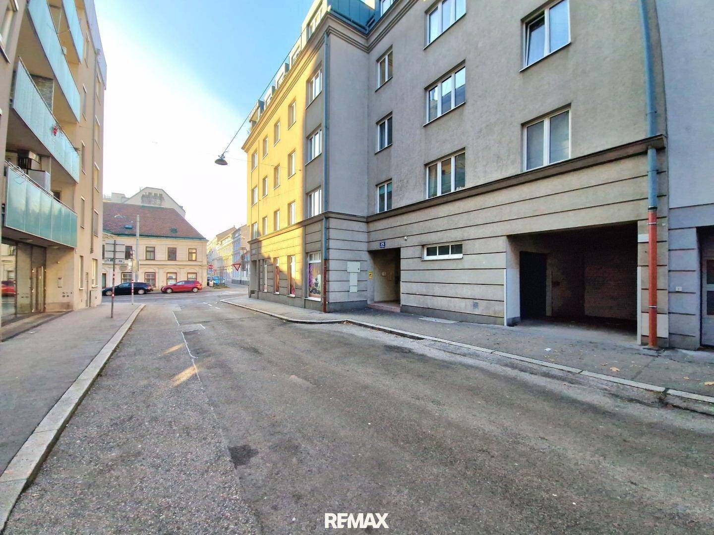 Straßenansicht eines Wohngebäudes mit Garagenzufahrt und umliegender Bebauung.