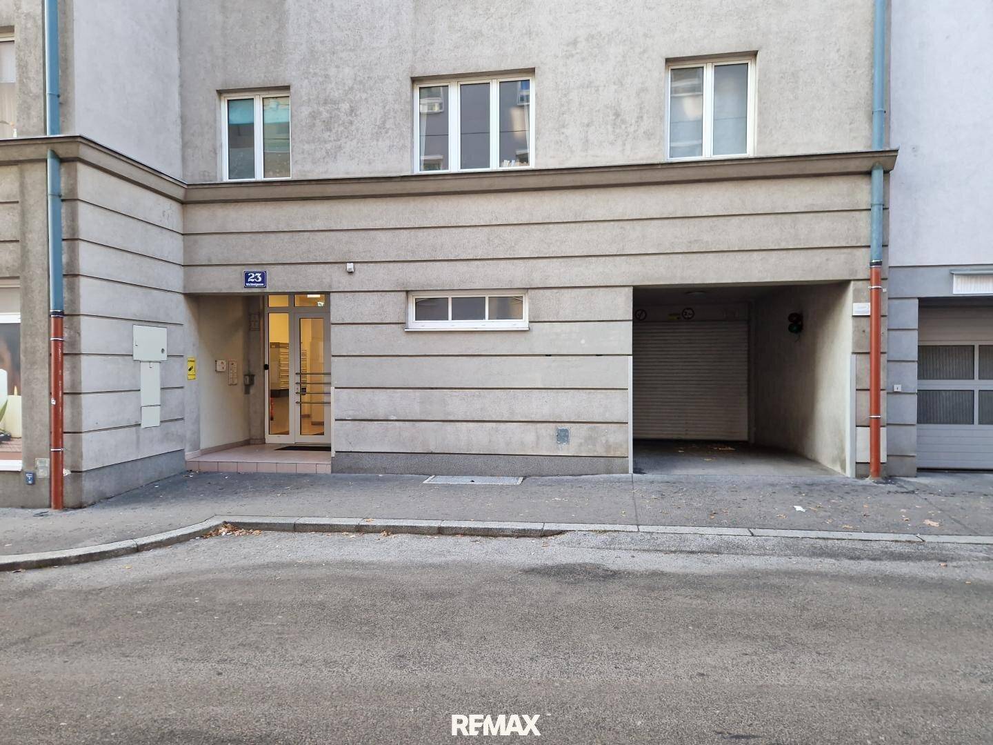 Fassade eines Wohngebäudes mit Eingangsbereich und Zufahrt zur Tiefgarage.