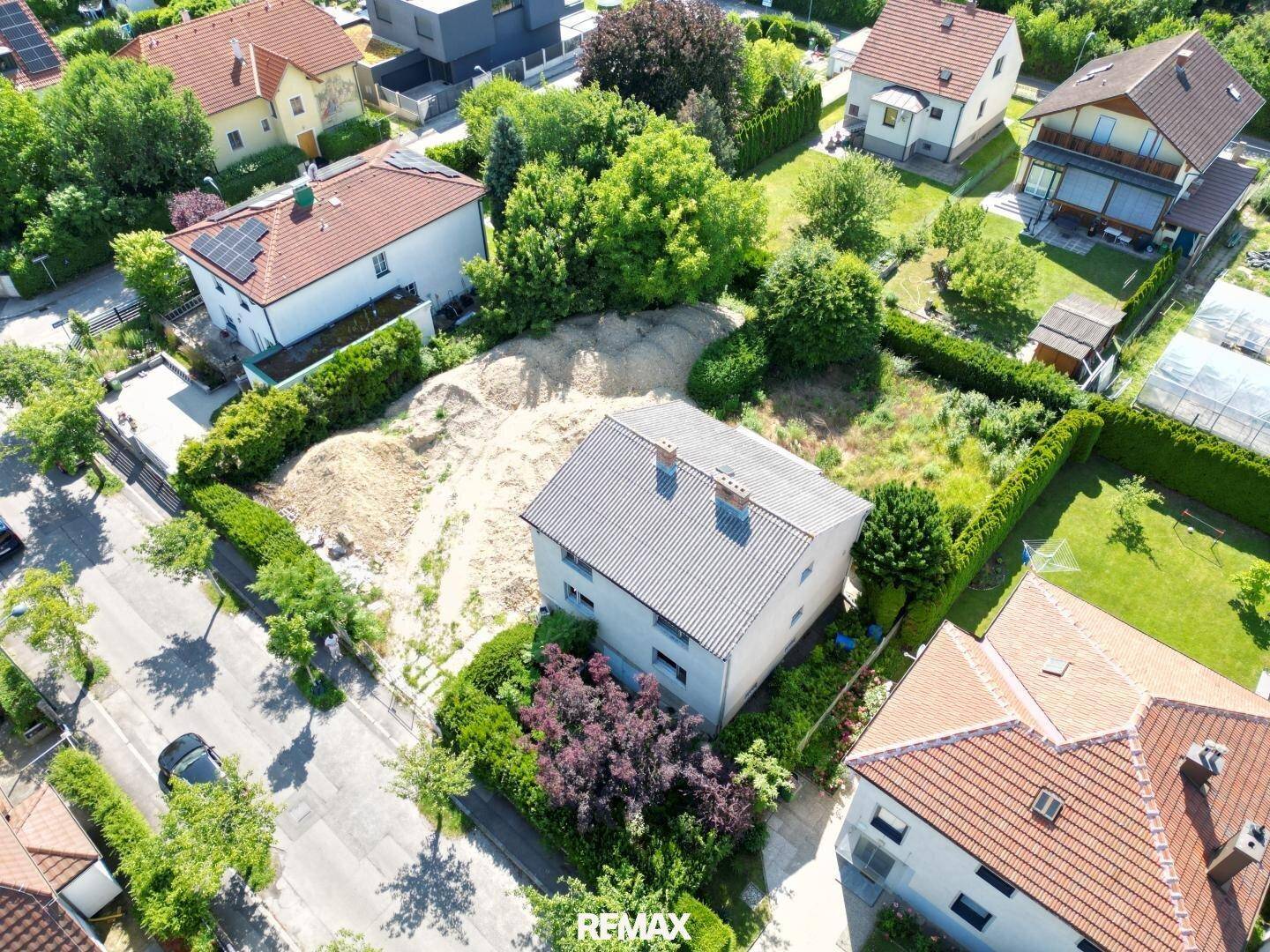 Luftaufnahme eines Grundstücks mit Bestandsgebäude und Baufläche in einer Wohnsiedlung.