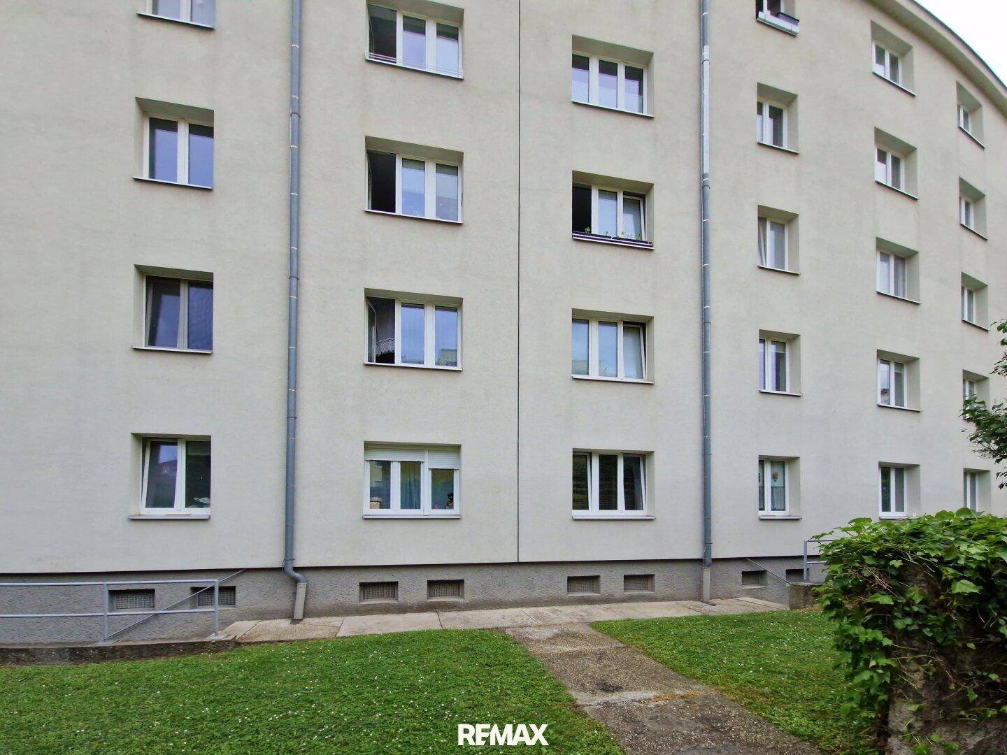Fassade eines Mehrfamilienhauses mit vielen Fenstern und schlichter Architektur.
