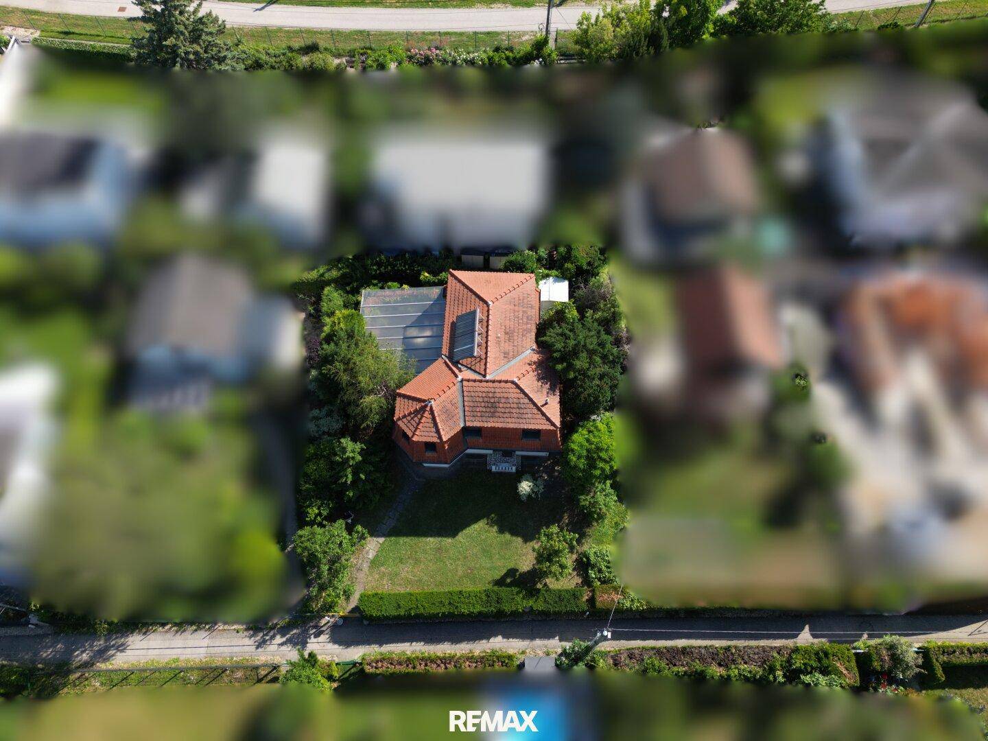 Weitläufige Luftaufnahme des Hauses mit großem Garten und umliegender Wohnbebauung.