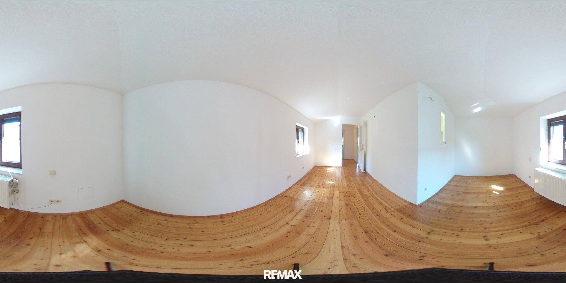 Helles Zimmer mit Holzfußboden, weißen Wänden und natürlichem Lichteinfall.