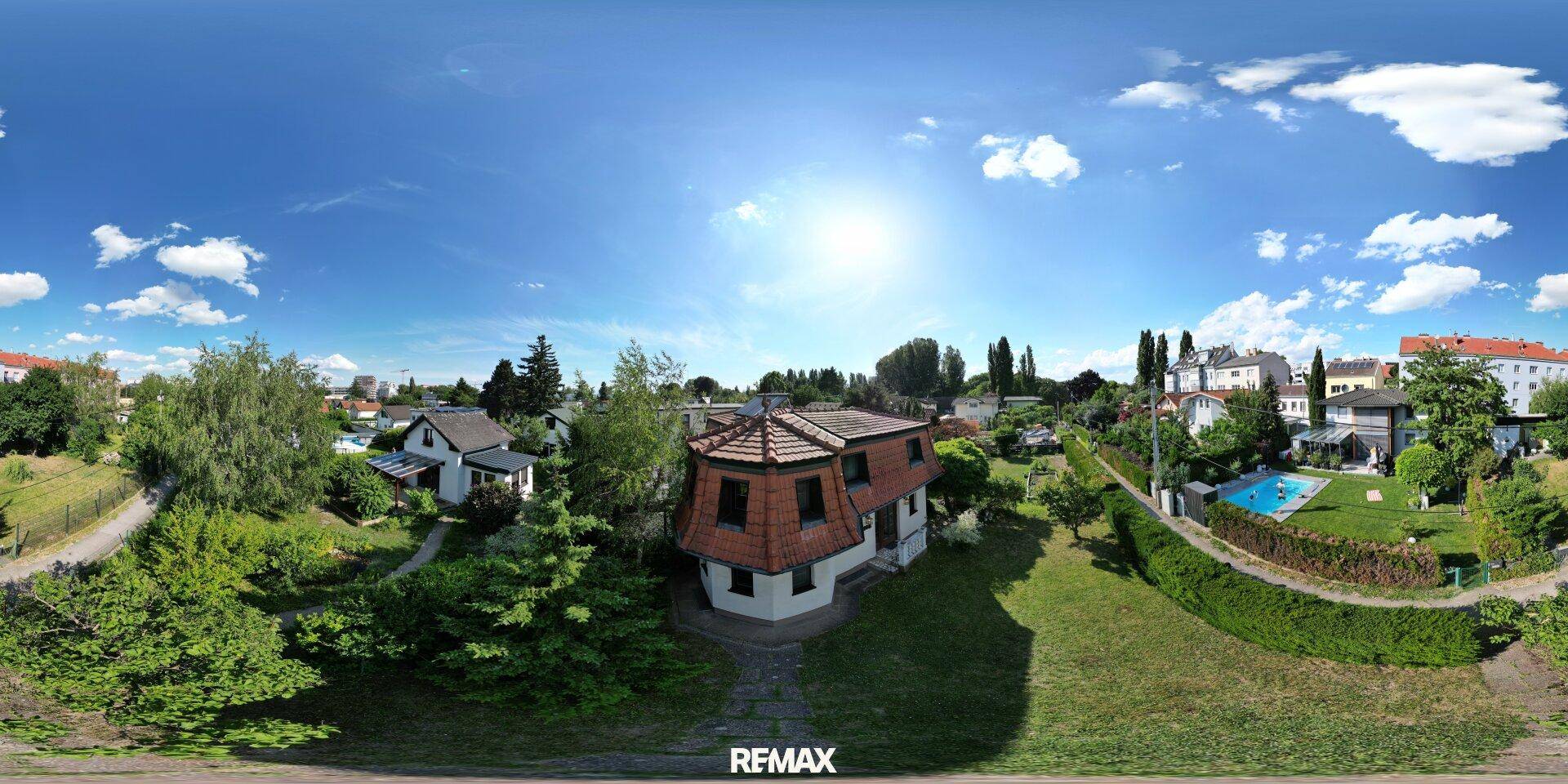 Weitwinkelaufnahme des Hauses mit großem Garten und Blick auf die Nachbarschaft.