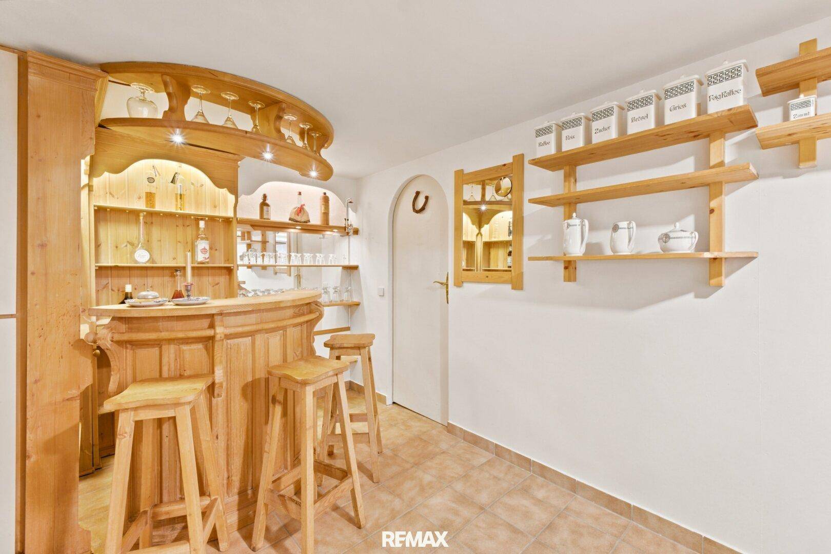 Rustikale Kellerbar mit Holzeinrichtung und Regalen, ideal für gesellige Abende.