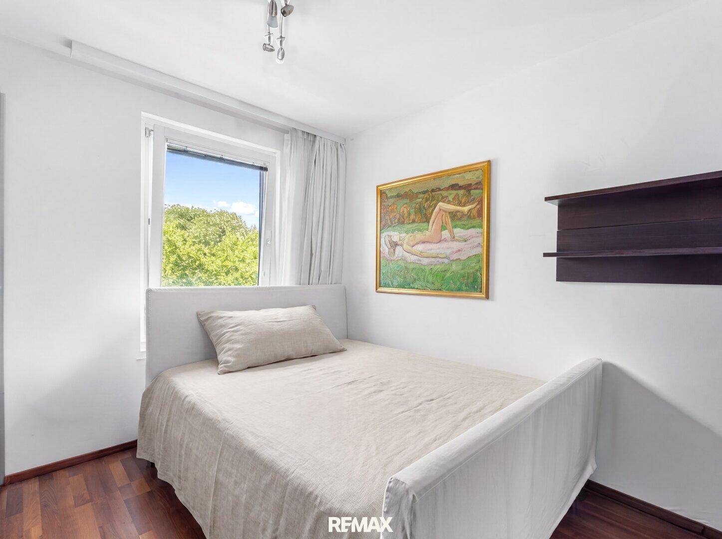 Helles Schlafzimmer mit Einzelbett, Fenster und Holzboden, ideal als Kinder- oder Gästezimmer.