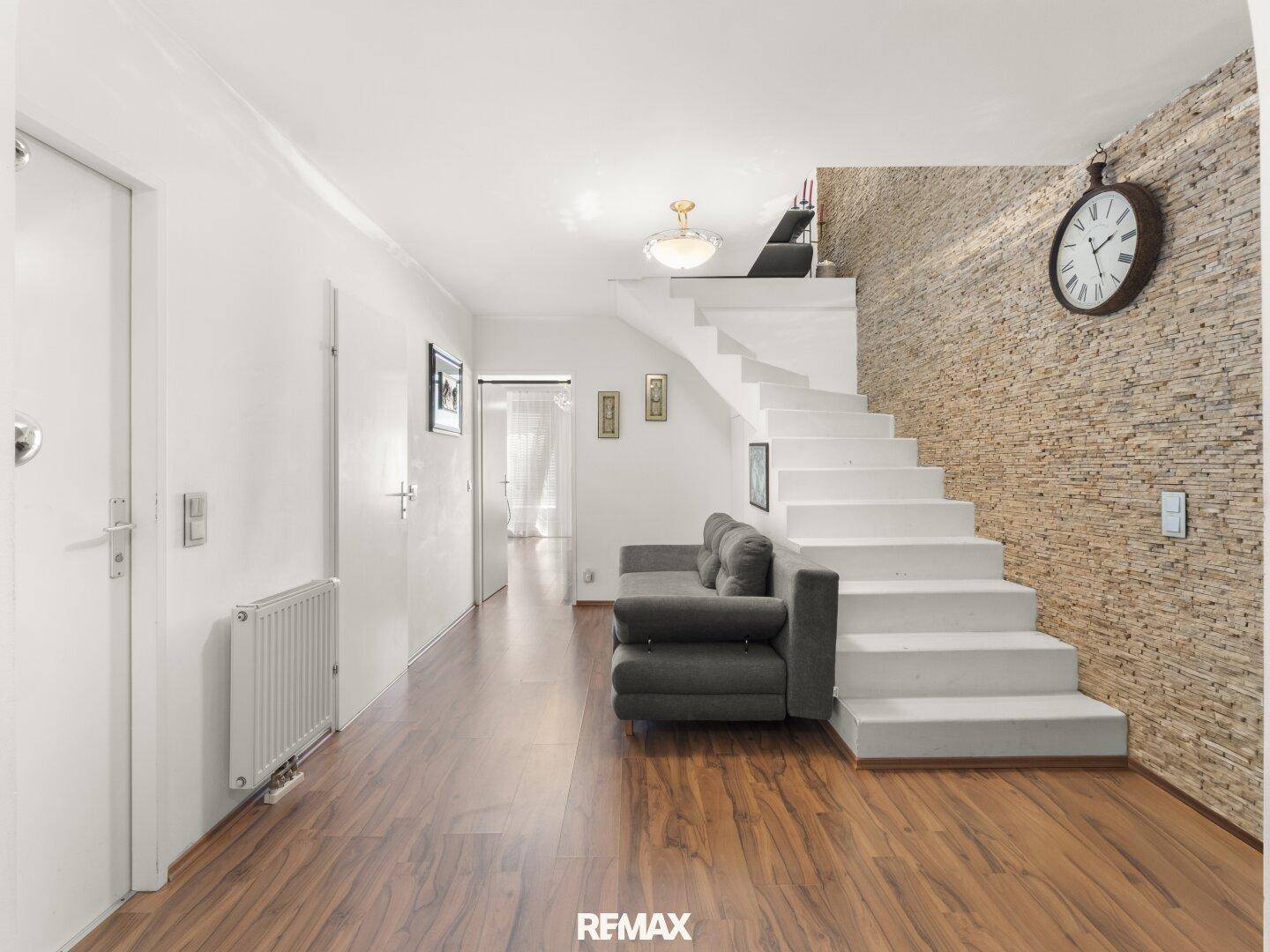 Geräumiger Flur mit Holzboden und Treppe, die zu den oberen Etagen führt, hell und offen.