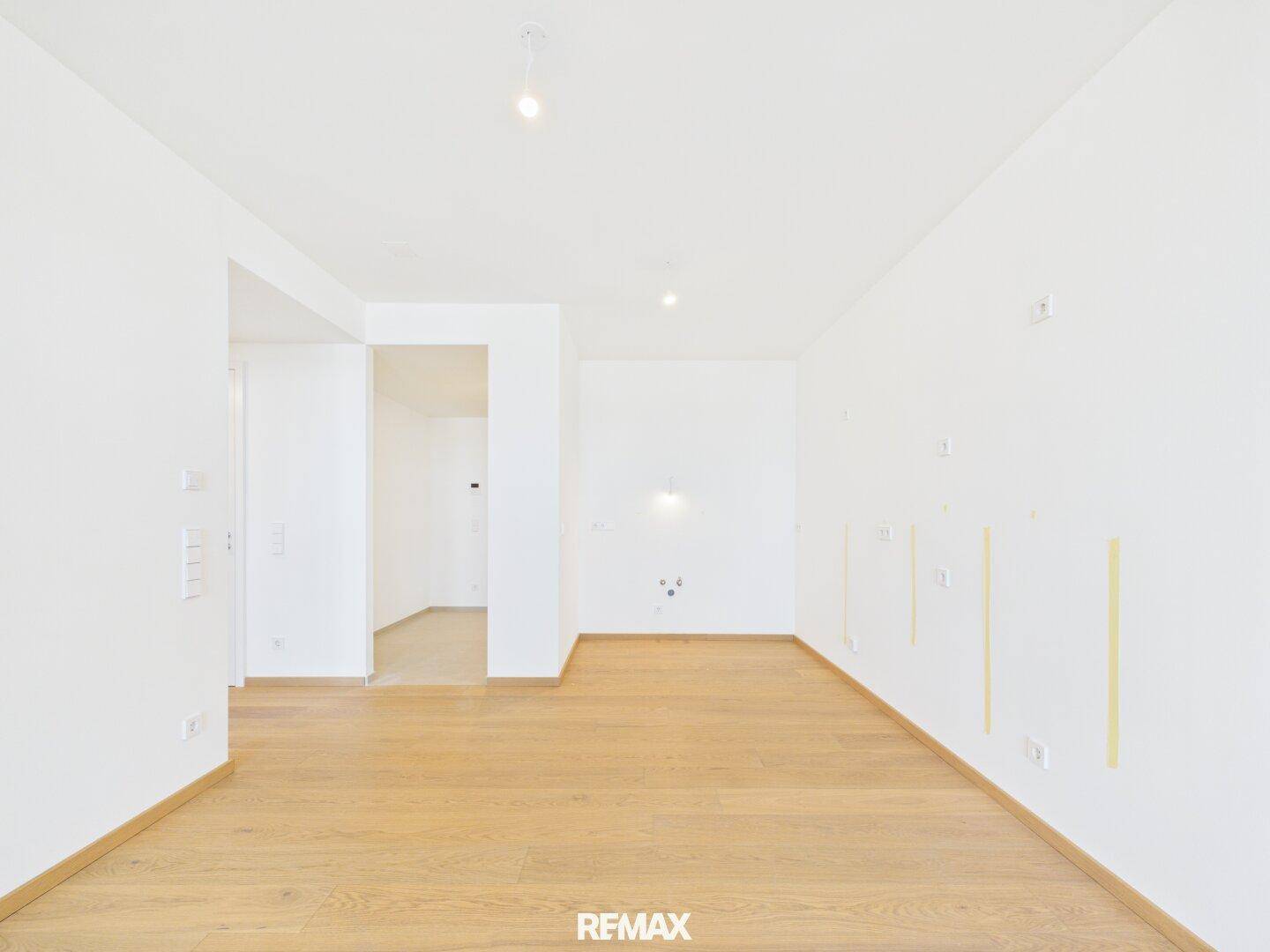 Geräumiges, leeres Zimmer mit Parkettboden und weiß gestrichenen Wänden, bereit zur Einrichtung.