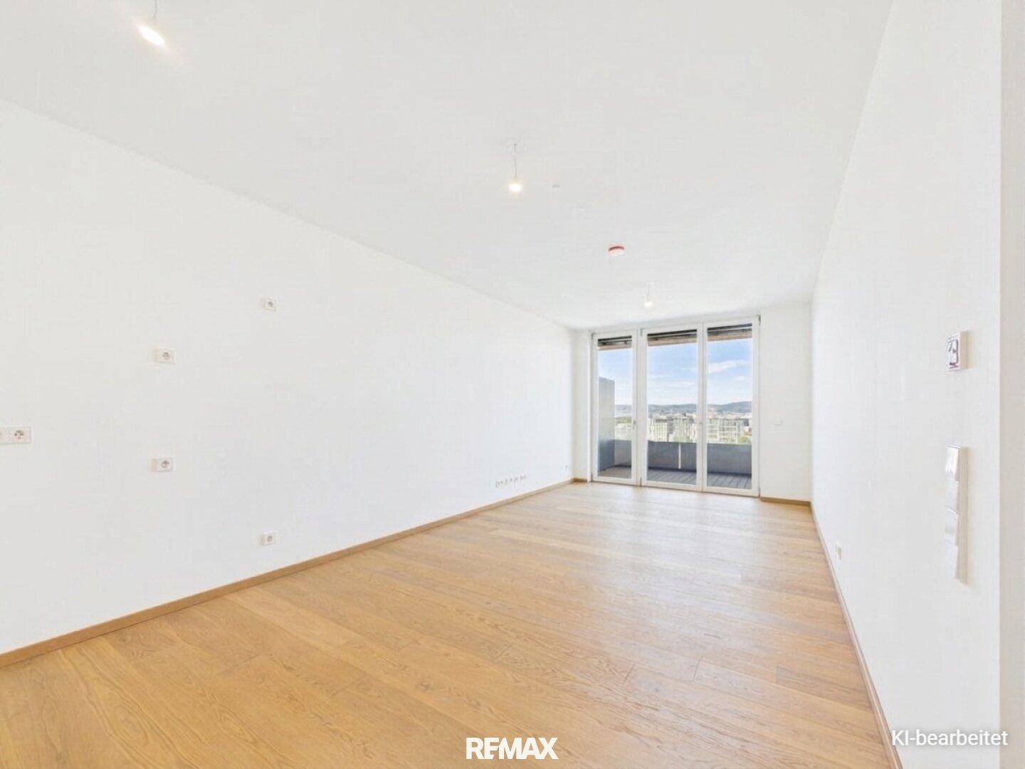 Helles Wohnzimmer mit Parkettboden und großen Fenstern, die Zugang zu einem Balkon bieten.