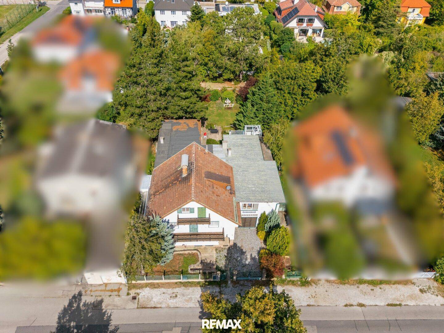 Luftaufnahme des Anwesens mit dem Haus und umliegenden Bäumen, eingebettet in eine grüne Umgebung.