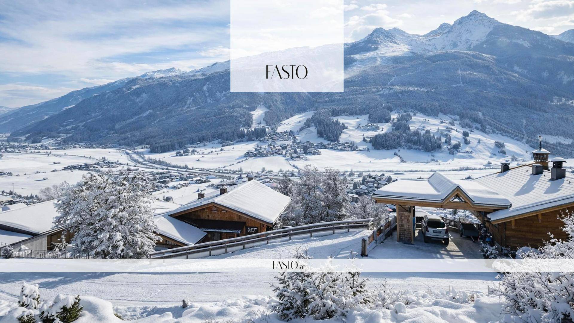 Winterlandschaft mit verschneiten Häusern, Bergen und einem Tal unter klarem Himmel.