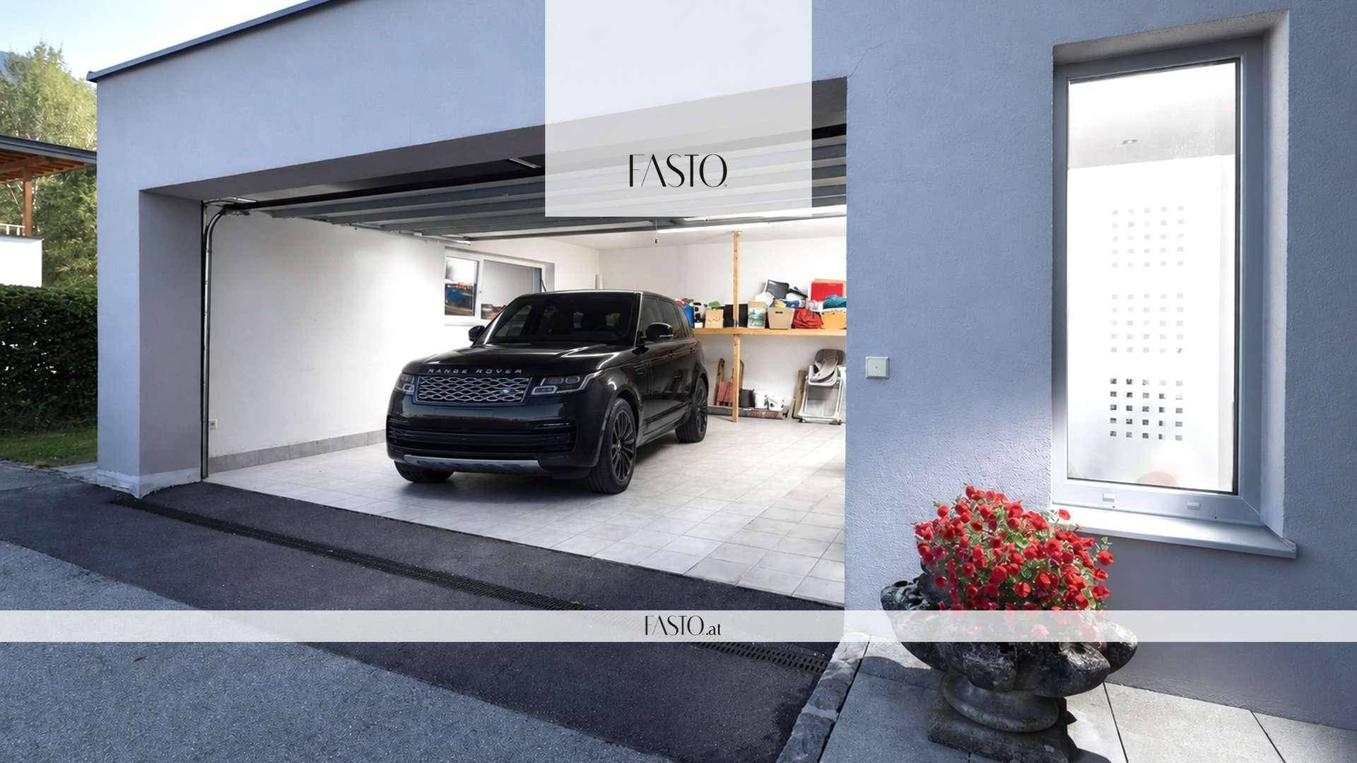 Geräumige Garage mit einem schwarzen SUV und praktischem Stauraum an den Wänden.