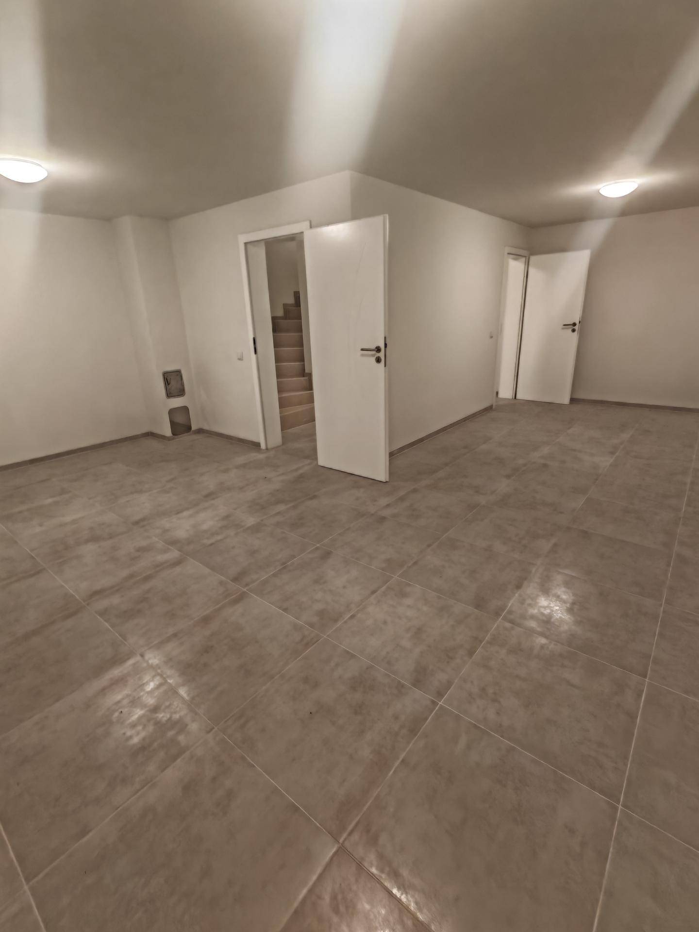 Geräumiger Flur mit Fliesenboden und Zugang zu verschiedenen Räumen und einer Treppe.