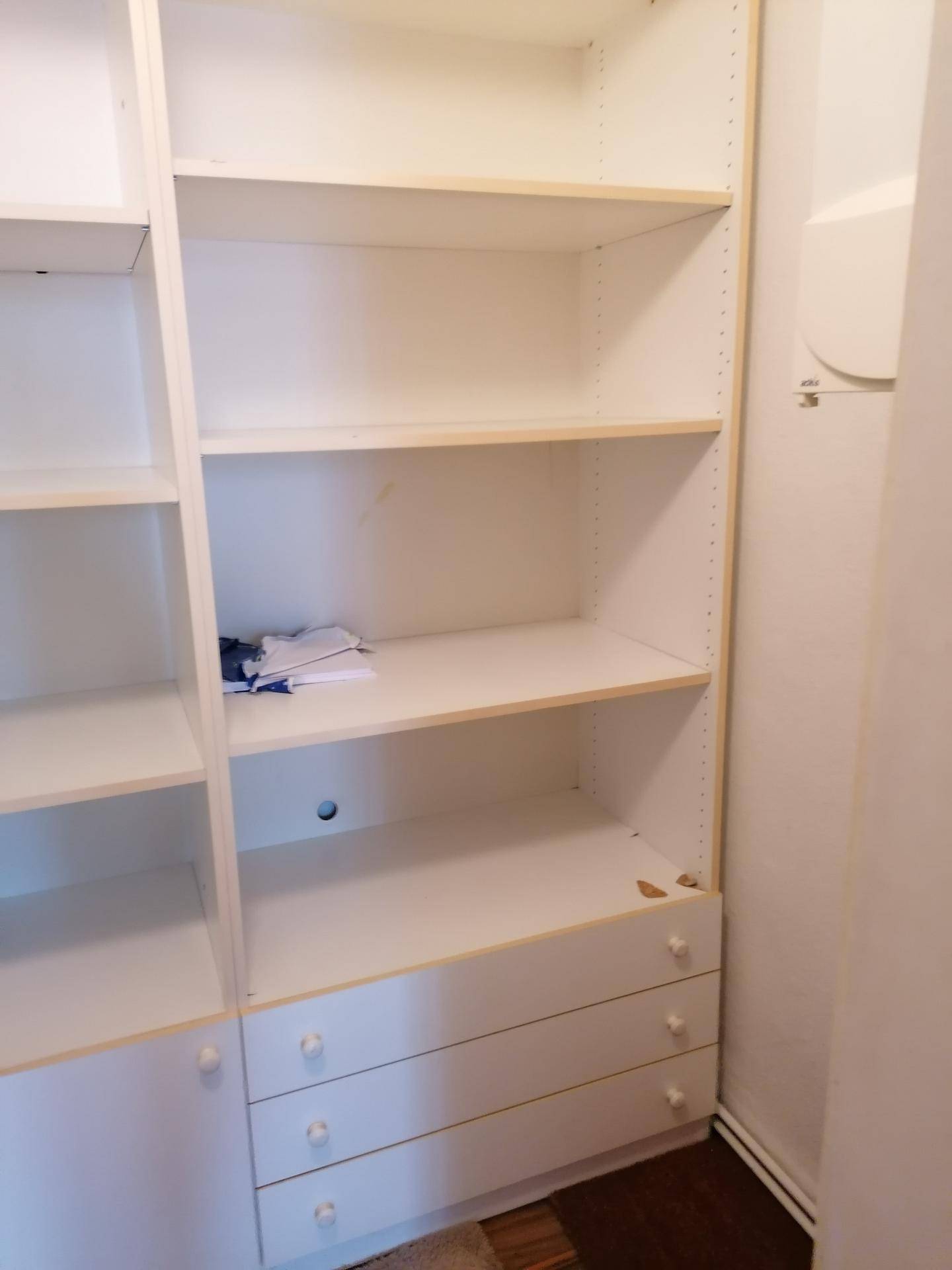 Weißes Einbauregal mit Schubladen, ideal für Stauraum oder Ankleidezimmer.