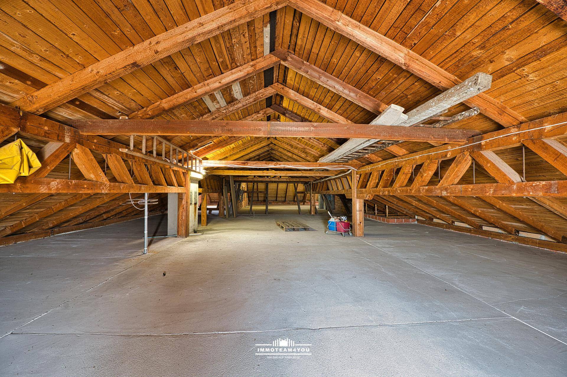 Großer, unausgebauter Dachboden mit sichtbarer Holzkonstruktion und viel Potenzial.