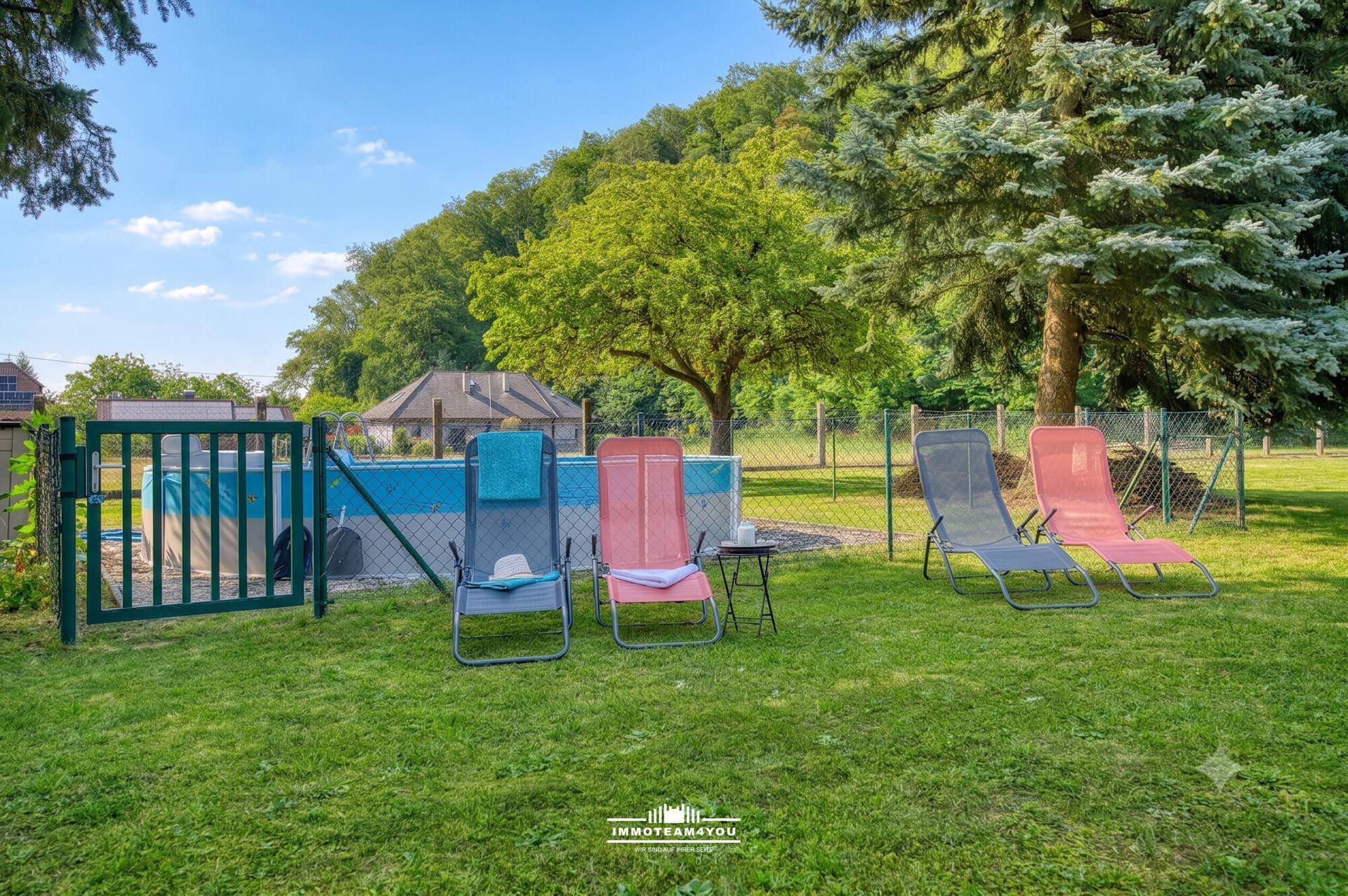 Gartenbereich mit Aufstellpool, Liegestühlen und umgebender Natur.