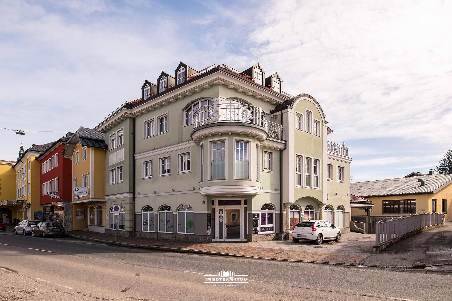 Historisches Gebäude mit eleganter Fassade, Erker und Mansarddach in einer städtischen Umgebung.