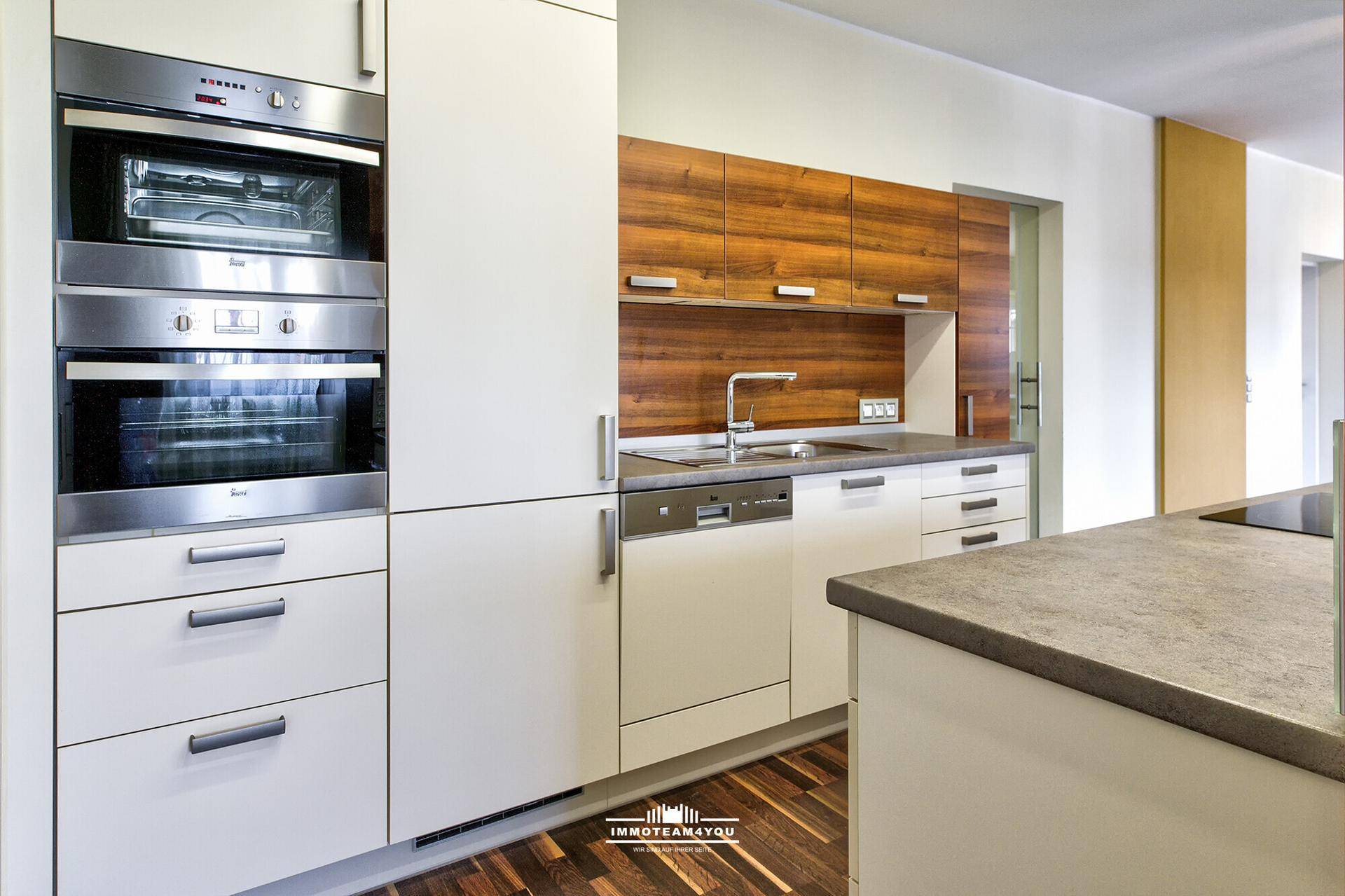Detailansicht der modernen Einbauküche mit Backofen, Dampfgarer und Geschirrspüler.