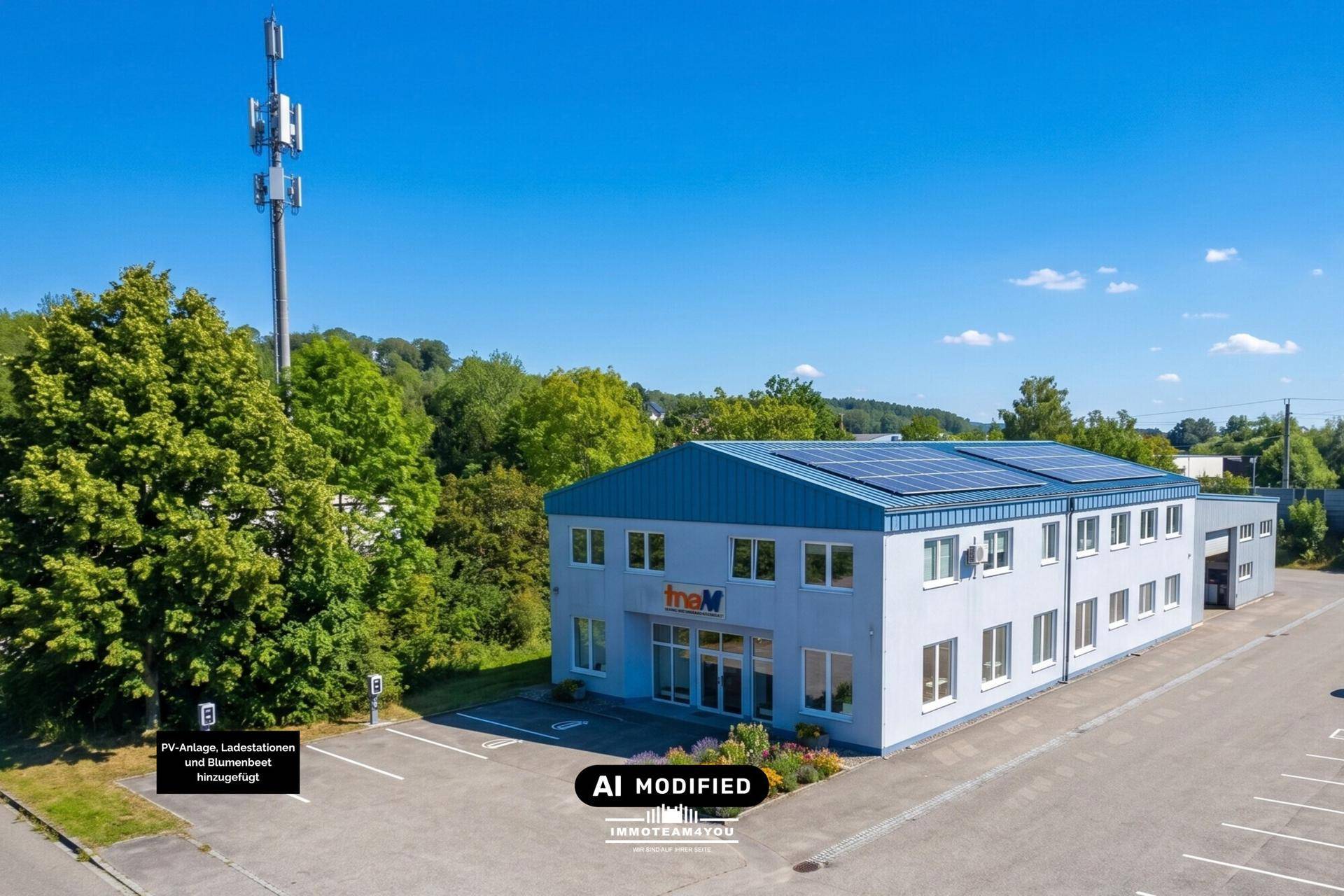 Das Geschäftsgebäude präsentiert sich mit einer Photovoltaikanlage und einem weitläufigen Parkplatz unter blauem Himmel.