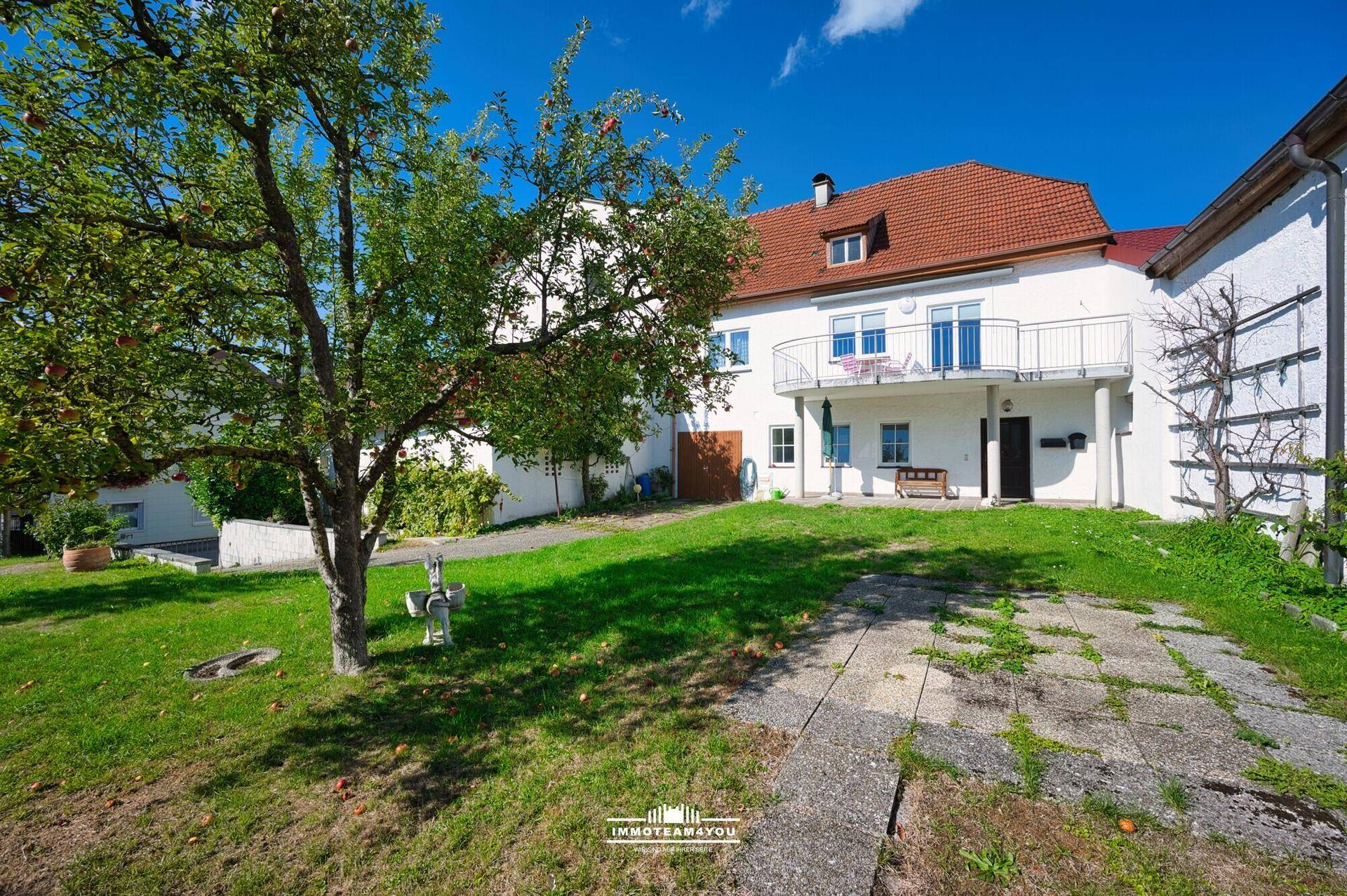 Freistehendes Wohnhaus mit großem Garten, Obstbaum und gepflasterter Zufahrt.