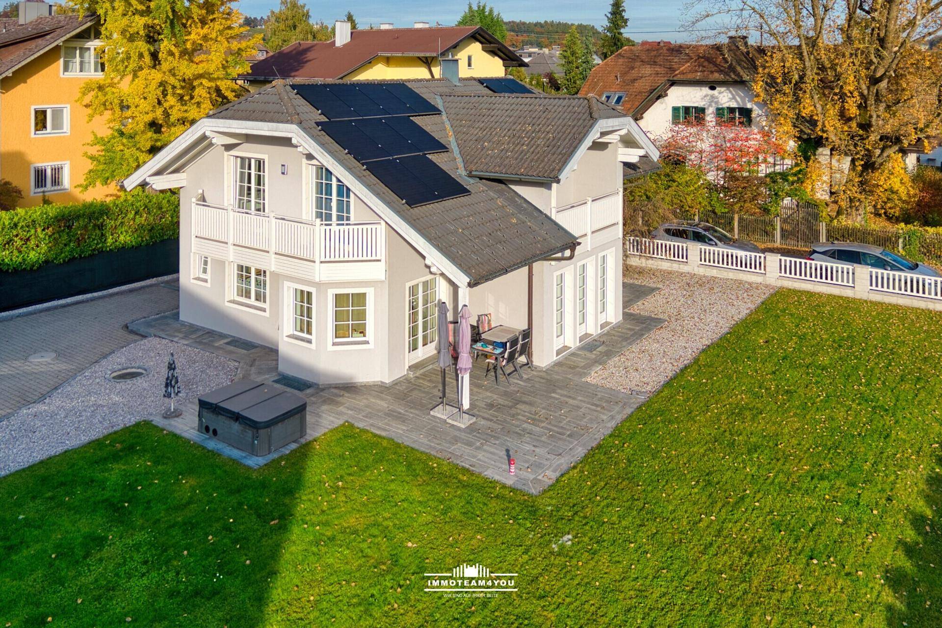 Luftaufnahme des modernen Einfamilienhauses mit Photovoltaikanlage und gepflegtem Gartenbereich.