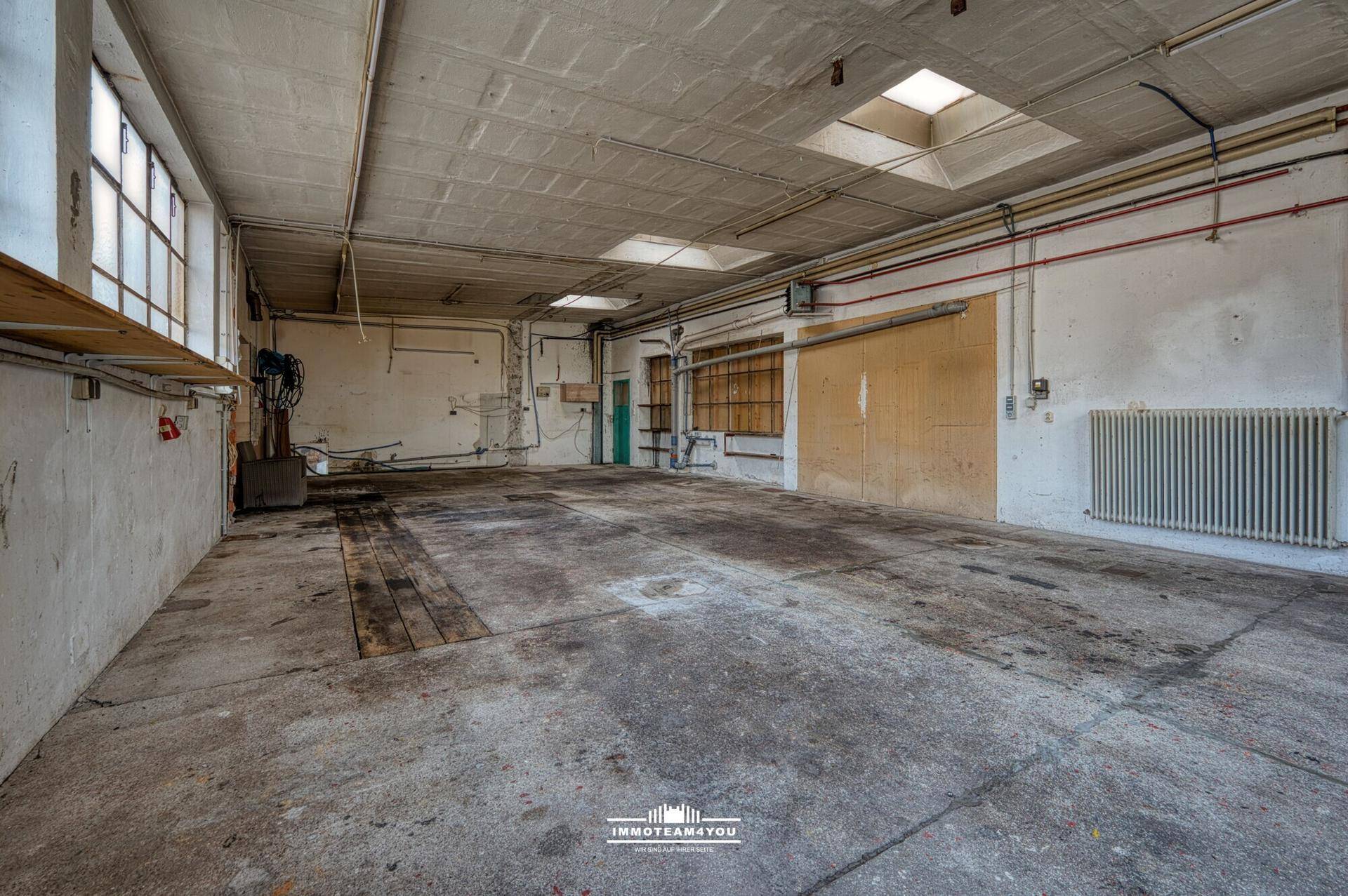 Große Werkstatt mit Betonboden, Heizkörper und viel Platz für Projekte und Lagerung.