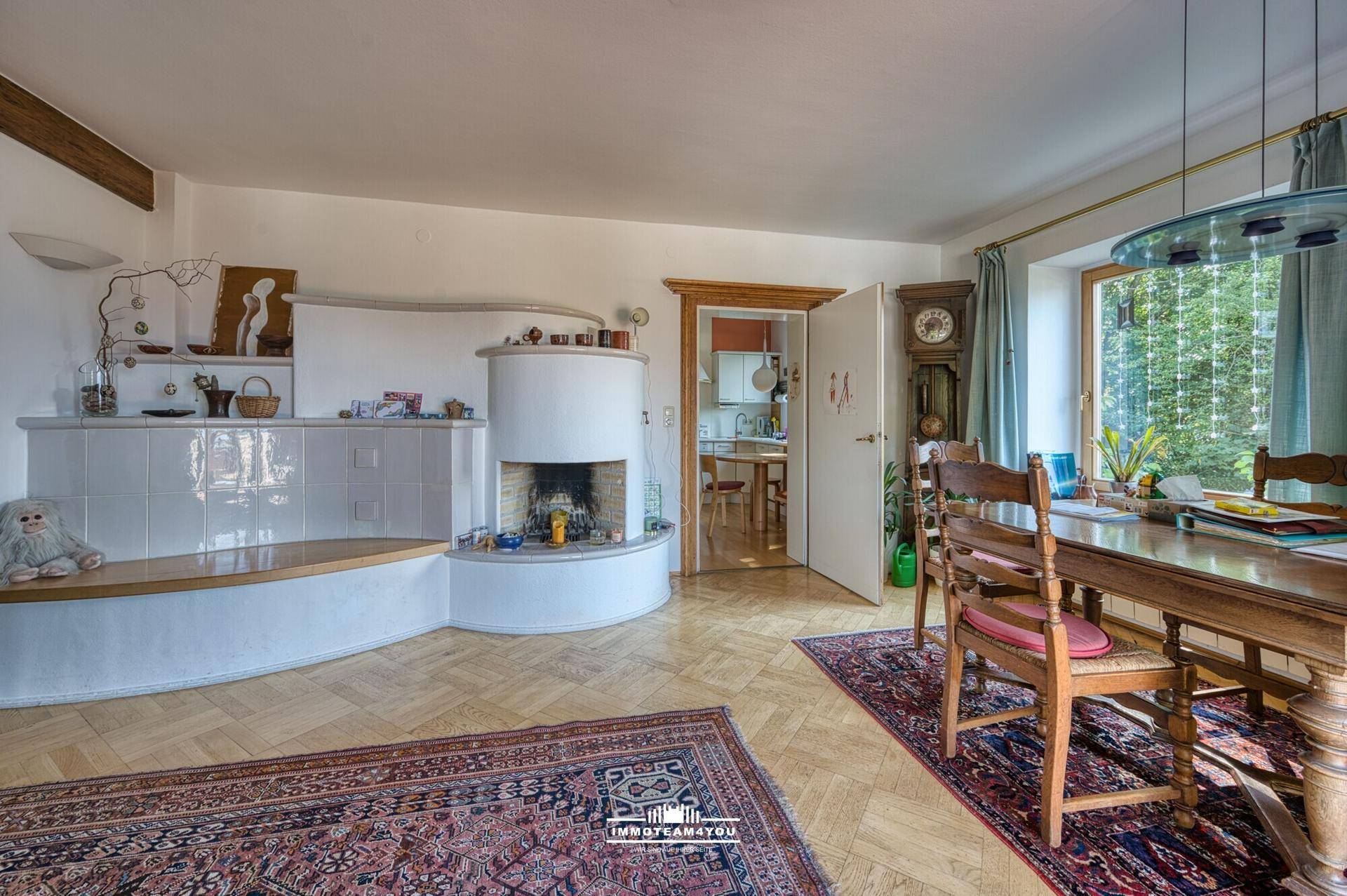 Gemütlicher Essbereich mit Holztisch, Stühlen und traditionellem Kachelofen im Wohnzimmer.