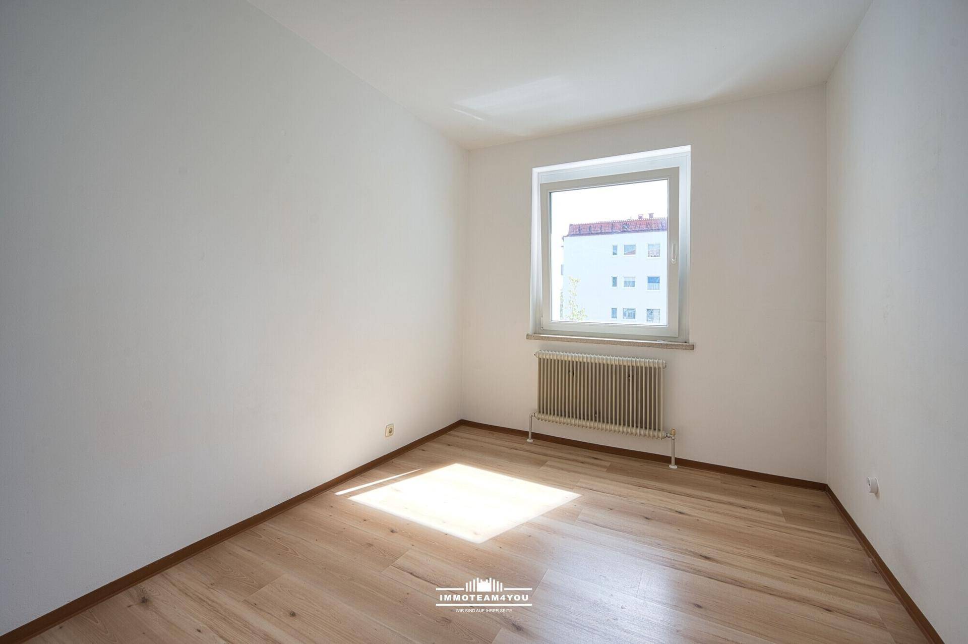 Sonniger Raum mit hellem Holzfußboden und einem Fenster, das viel natürliches Licht spendet.