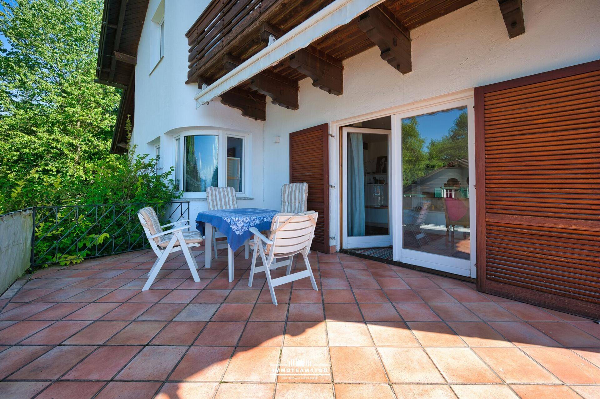 Gemütliche Terrasse mit Terrakottafliesen und Gartenmöbeln, ideal für entspannte Stunden im Freien.