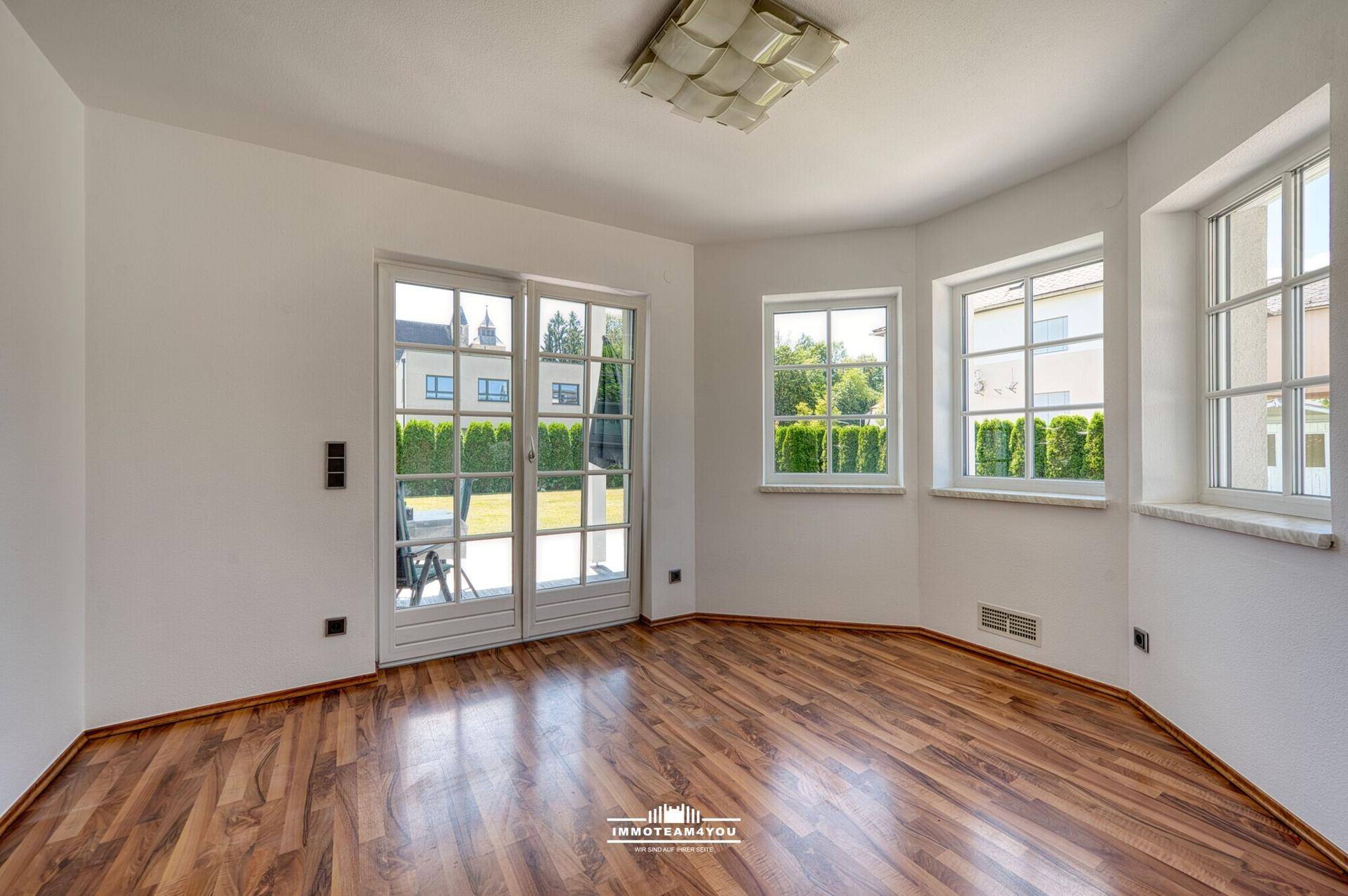 Heller Essbereich mit Laminatboden und Zugang zur Terrasse durch große Glastüren.