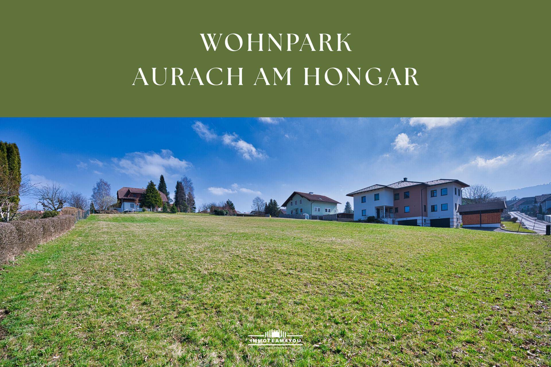 Idyllische ländliche Umgebung mit grünen Feldern und Wohnhäusern unter blauem Himmel.