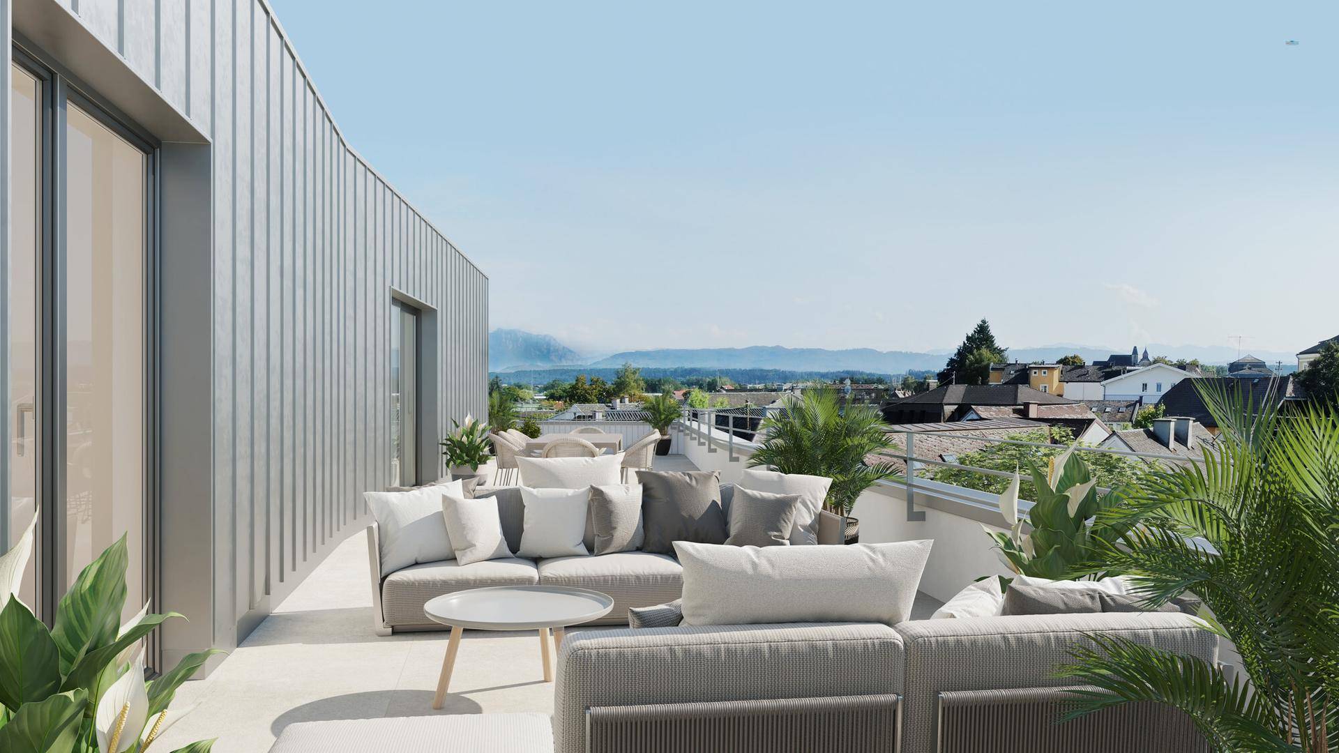 Geräumige Dachterrasse mit modernen Lounge-Möbeln und weitem Blick über die Landschaft und Berge.