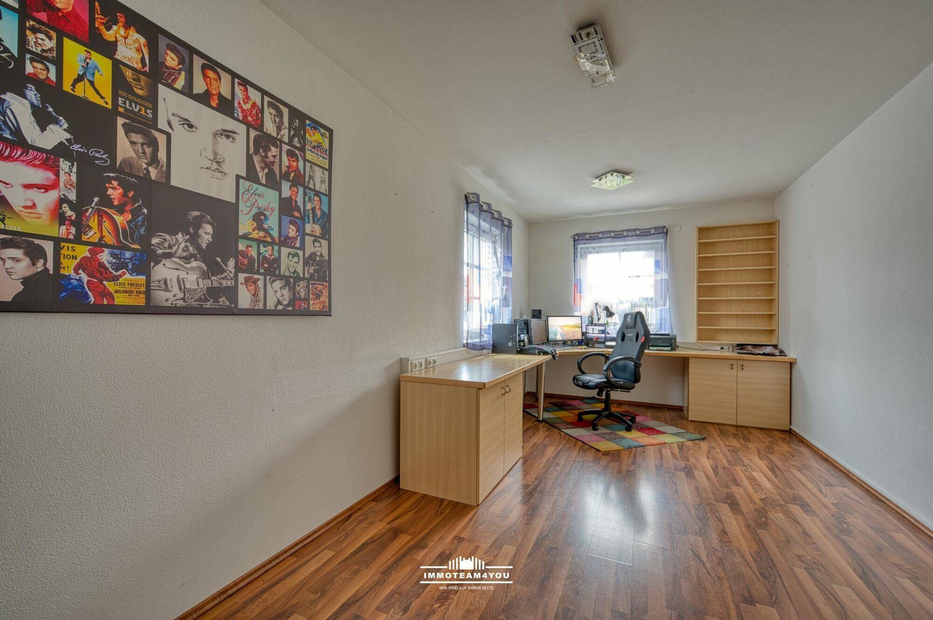 Geräumiges Arbeitszimmer mit Laminatboden, Schreibtisch und Fenster.