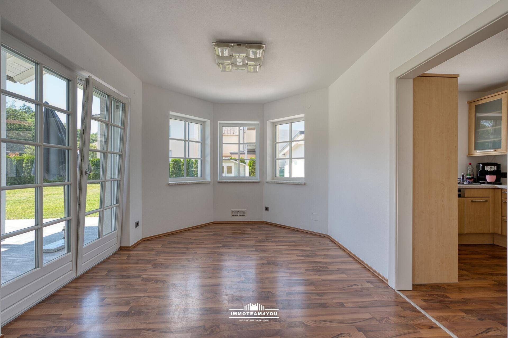 Essbereich mit Laminatboden und Blick in die angrenzende Küche.