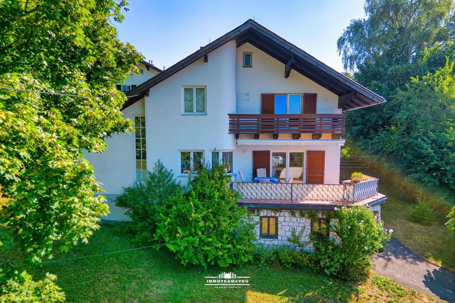 Ansicht des Hauses mit mehreren Balkonen und traditionellen Holzdetails unter blauem Himmel.