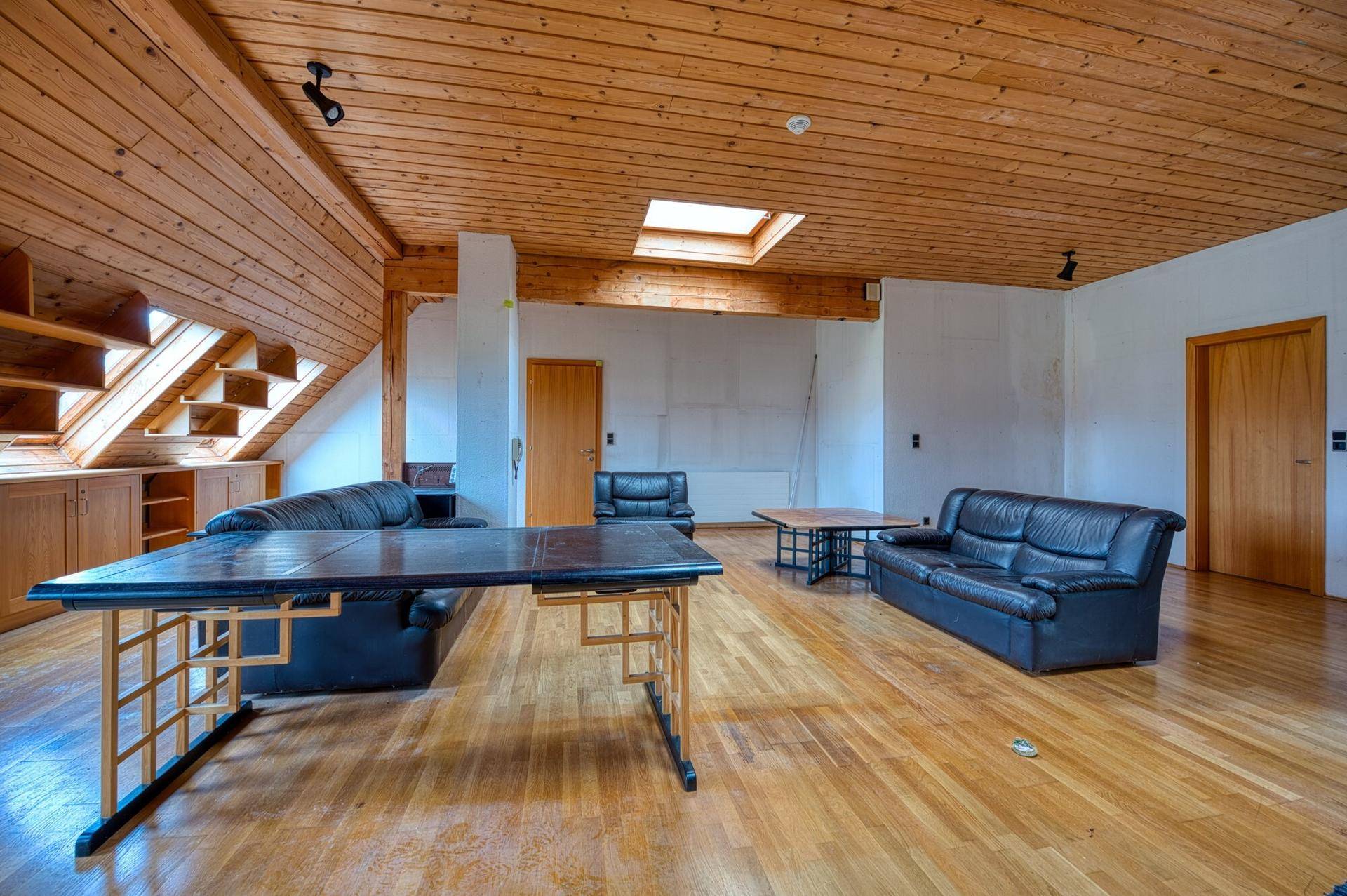 Großzügiger Dachbodenbereich mit Holzverkleidung, Holzboden und Dachfenster, vielseitig nutzbar.