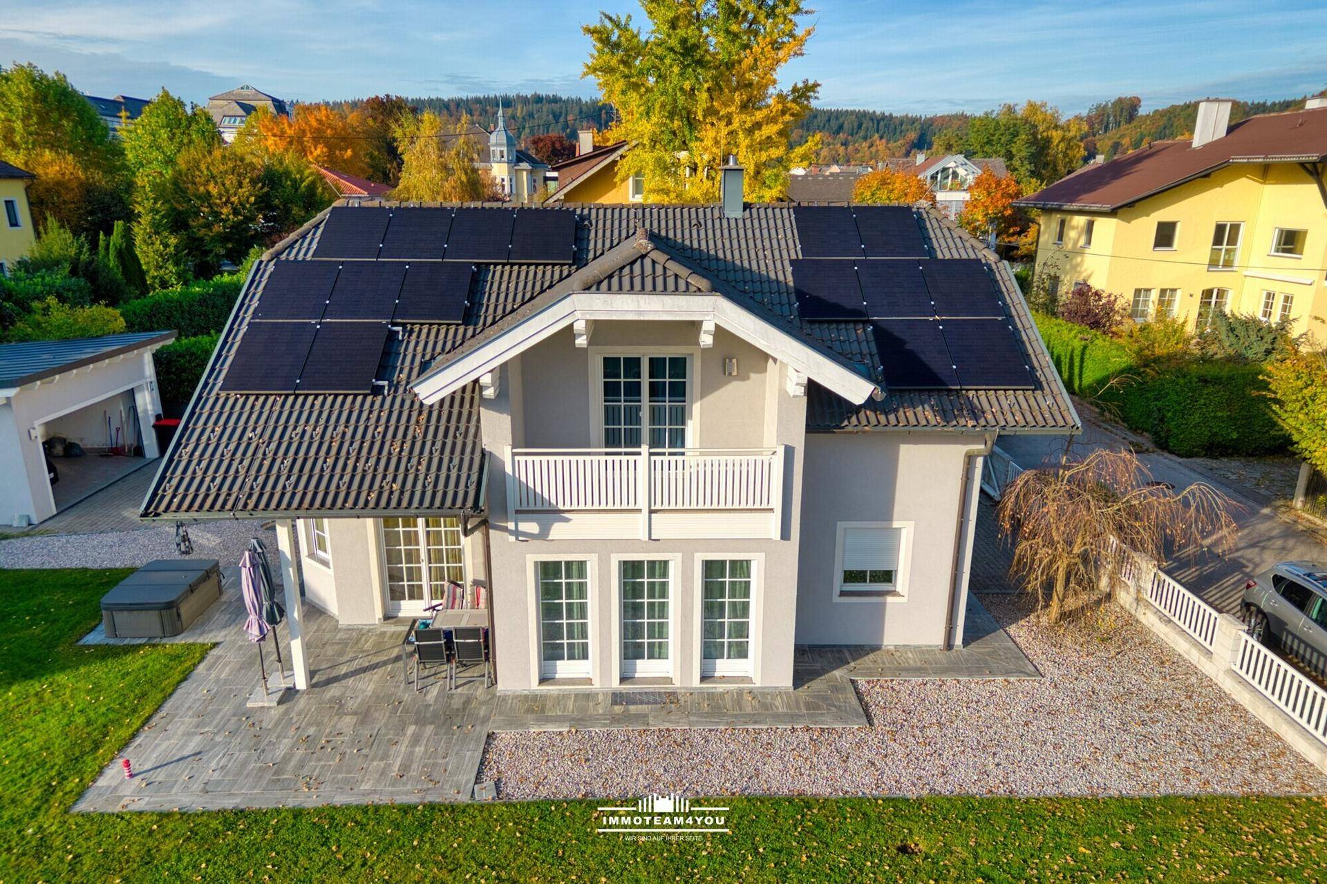 Vogelperspektive eines Einfamilienhauses mit Photovoltaikanlage und Gartenbereich.