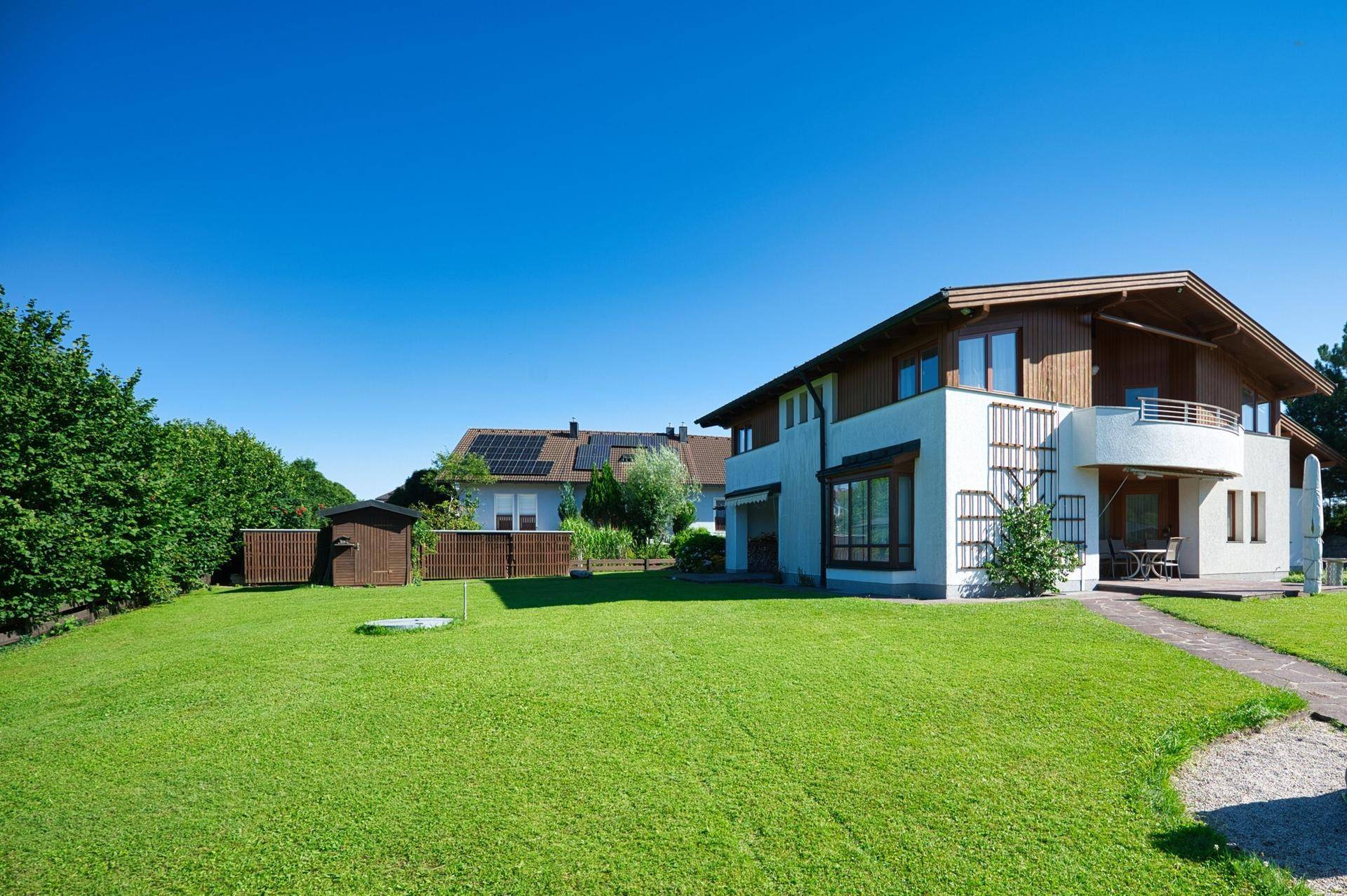 Gepflegter großer Garten mit Rasenfläche und Gartenhaus neben dem Einfamilienhaus.